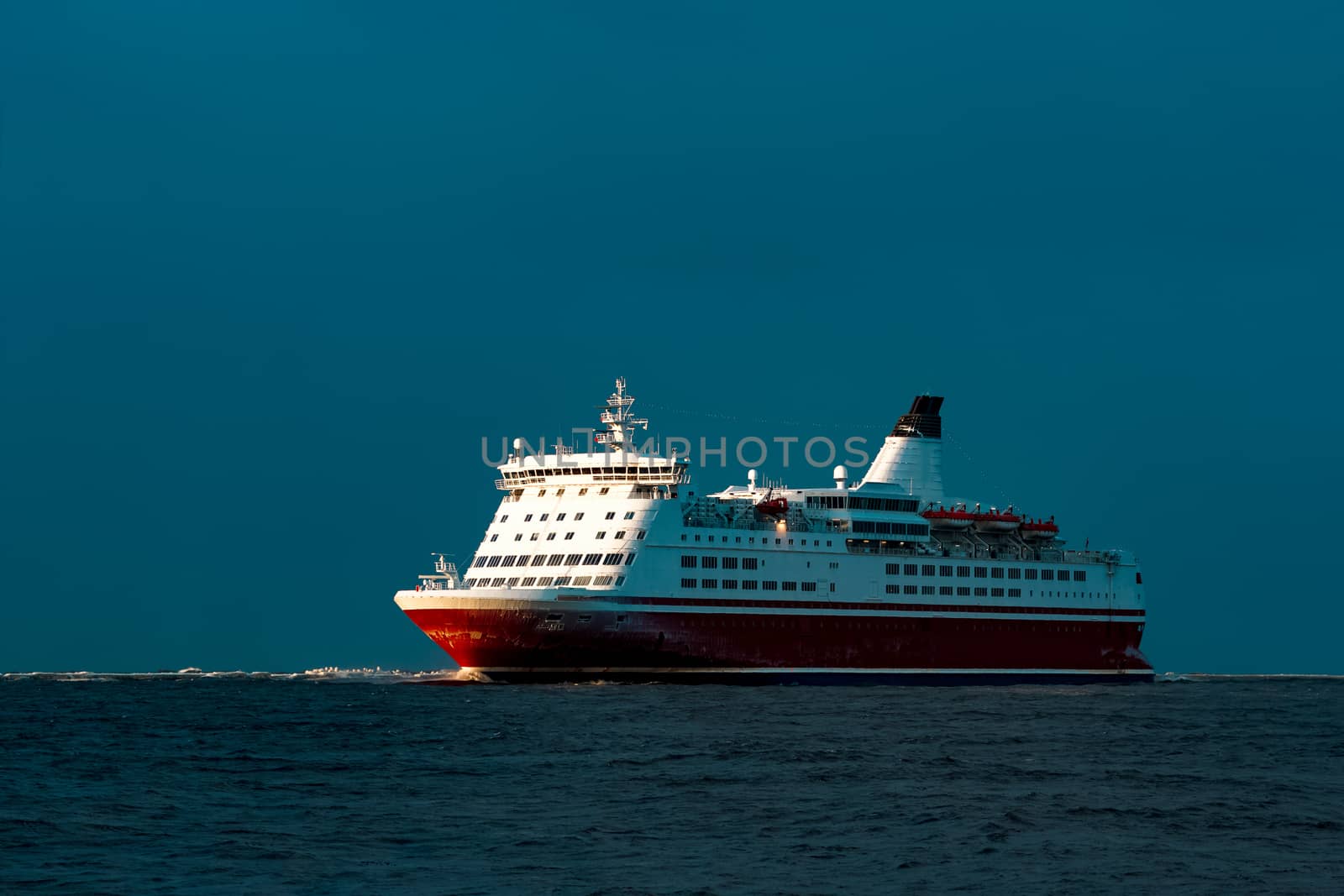 Red cruise liner. Passenger ship sailing from the sea in the morning