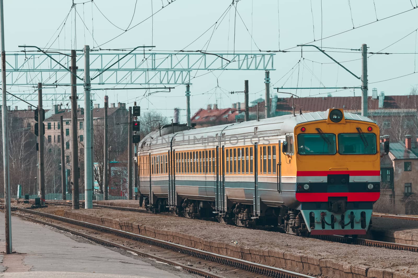 Old yellow passenger diesel train moving at the terminal