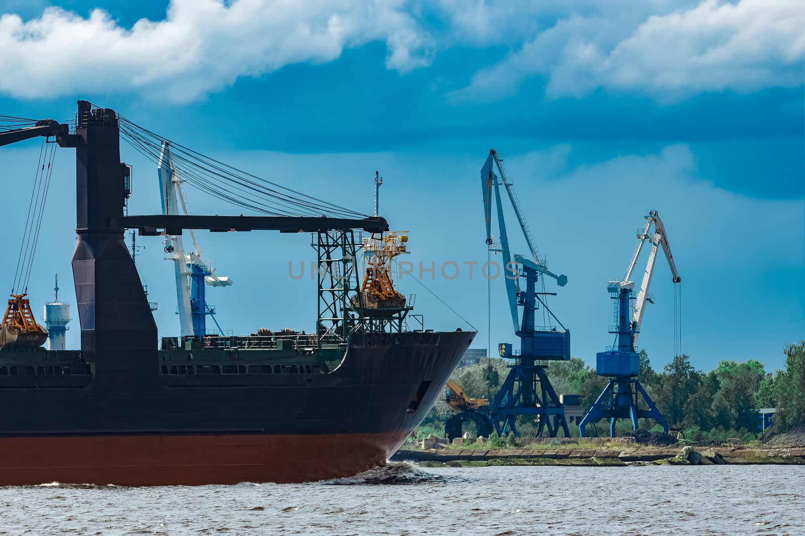 Merchandise import. Large blue cargo ship moving to Riga port