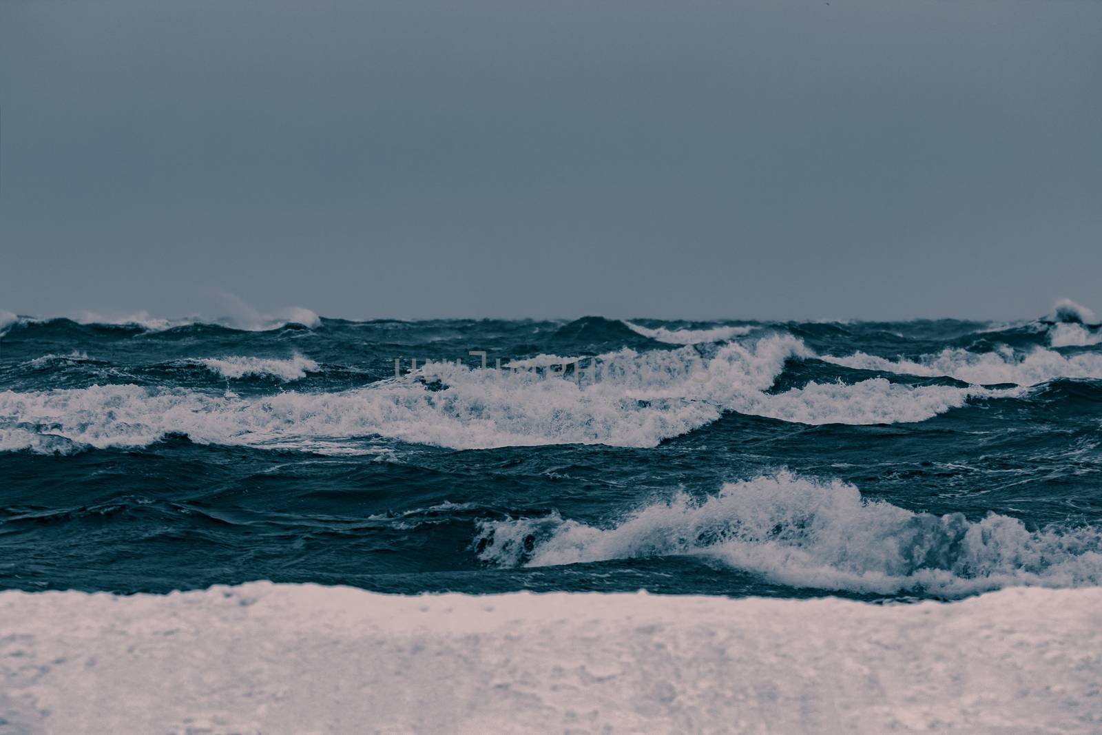 Big waves at the sea in stormy weather. Toned dark blue