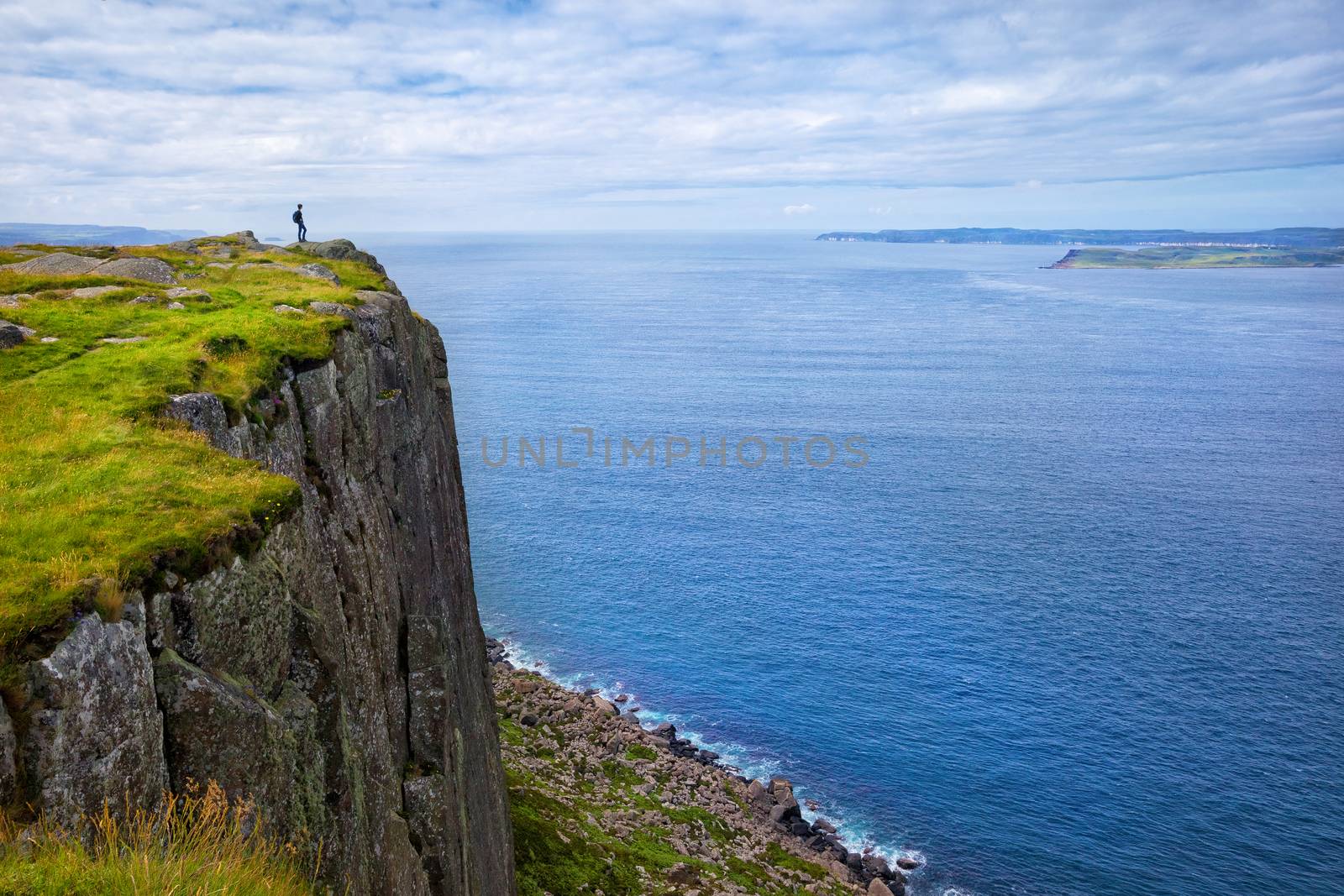tourist with backpack standing on the cliff Fair Head, Northern Ireland, UK by zhu_zhu