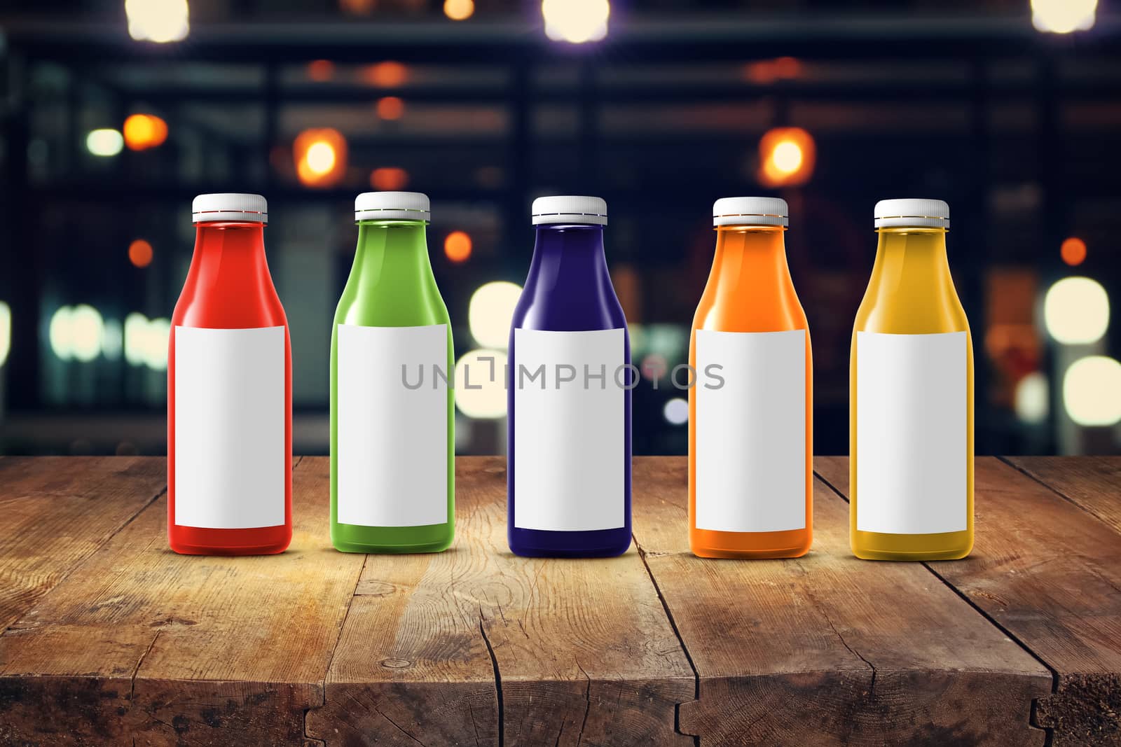 five multicolored bottles of juice are on the counter