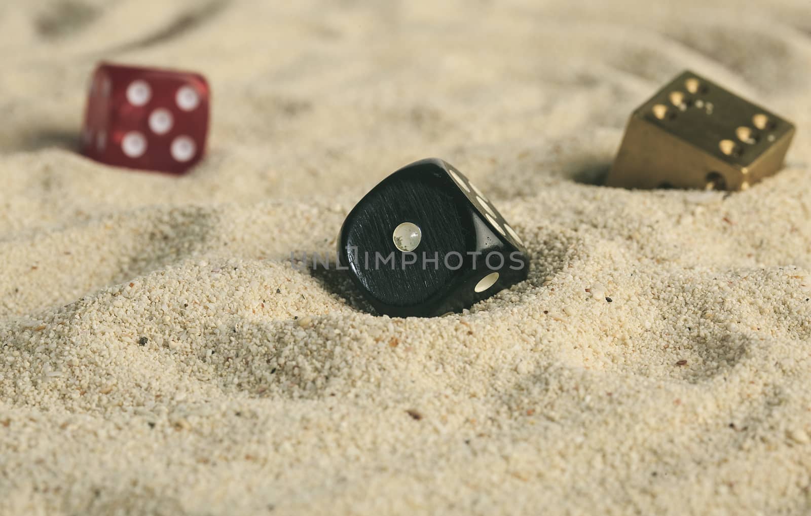 some dices buried in the sand dunes