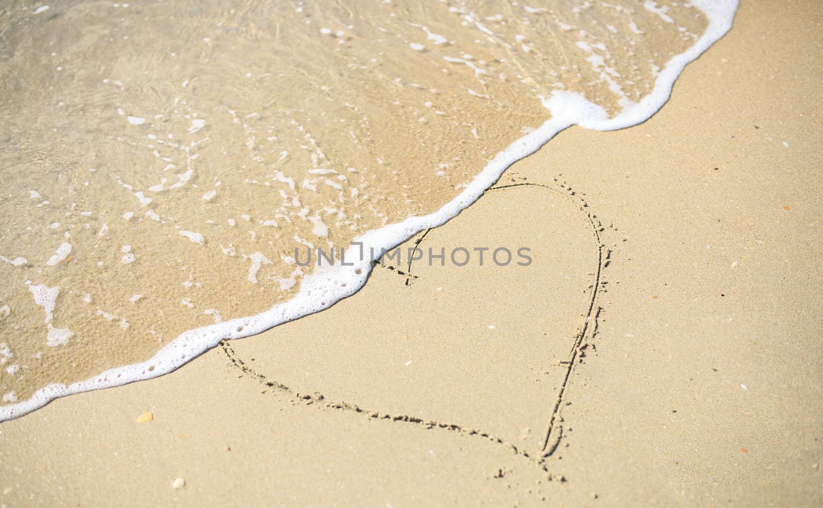 Love heart sign draw on the sand beach