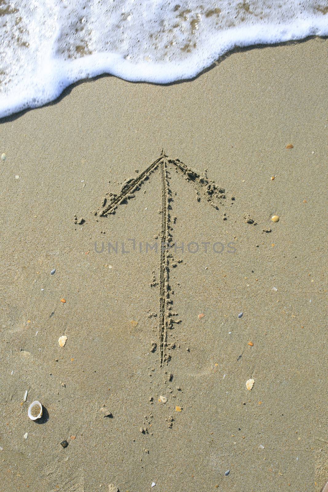 Arrow drawn on the sand beach