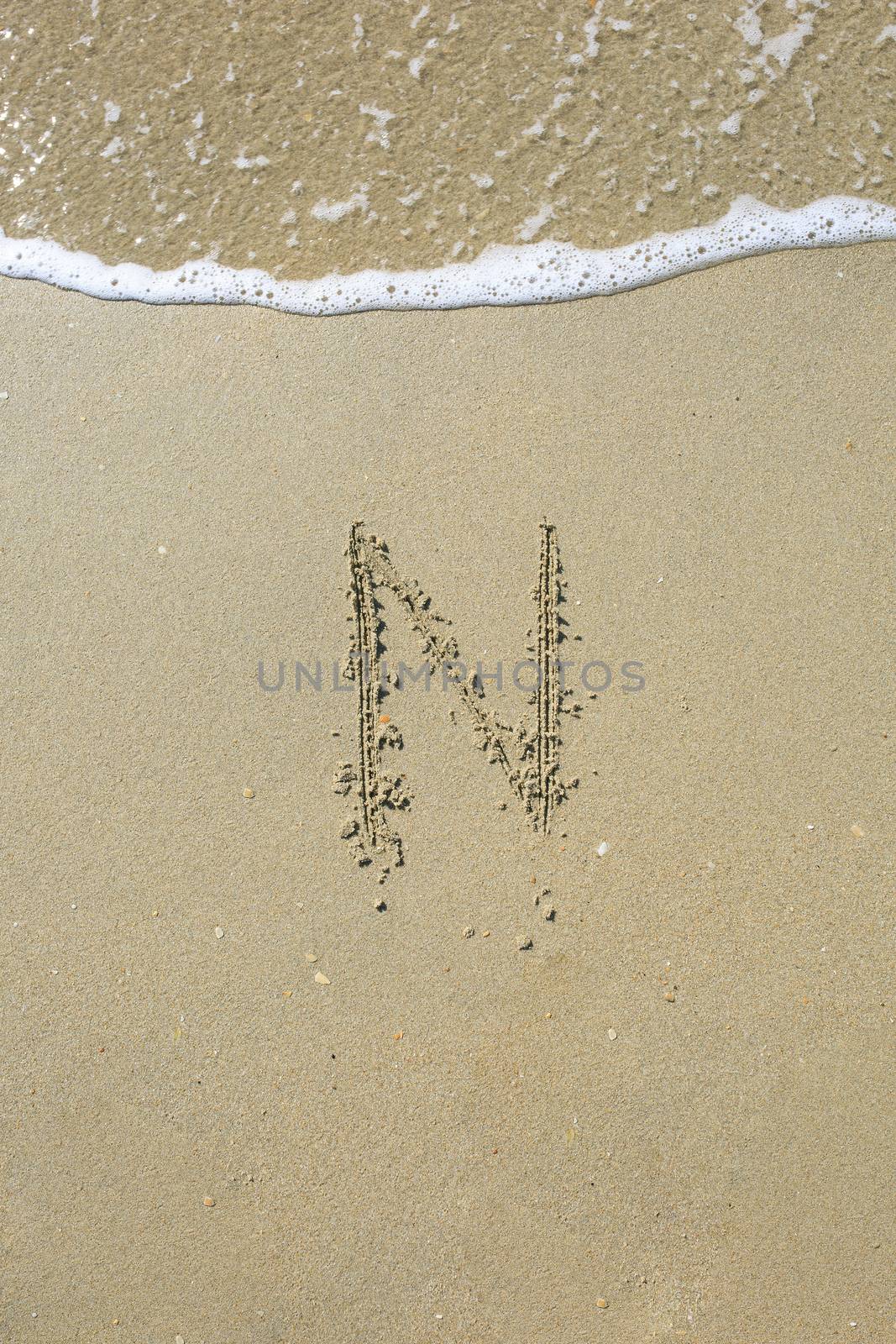 Letter drawn on the sand beach