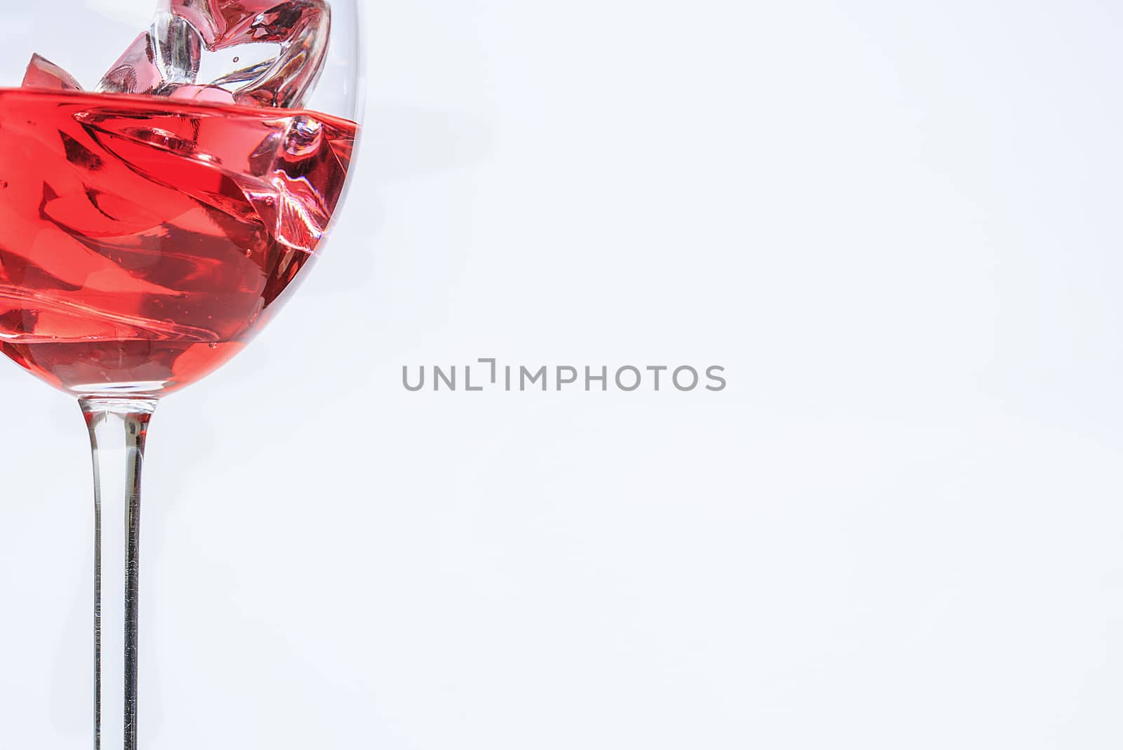 Glass cup with red liquid and ice