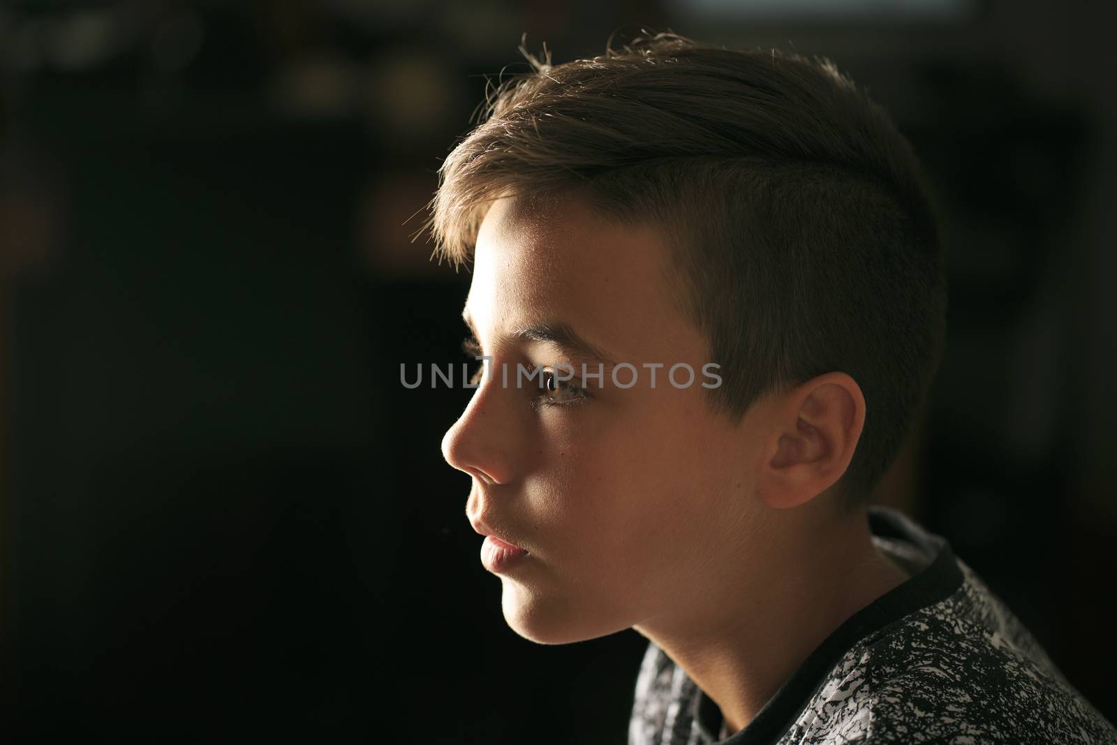 Boy with green eyes looking at the television