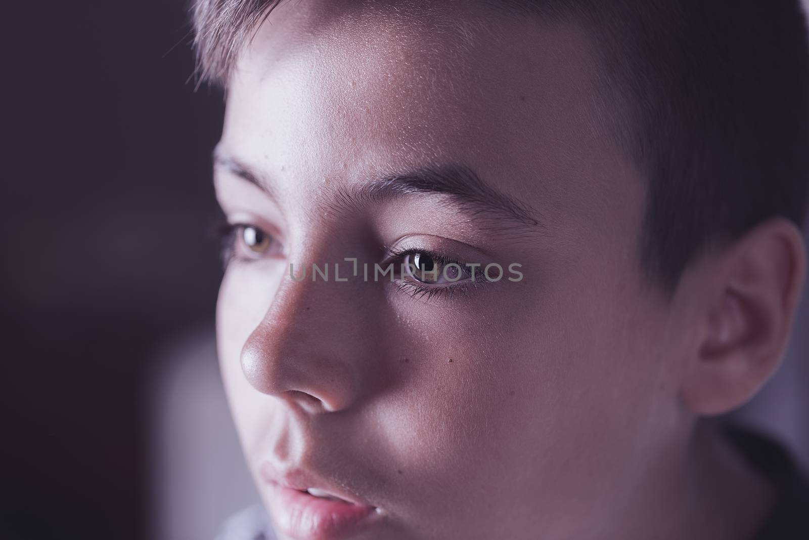 Boy with green eyes looking at the television