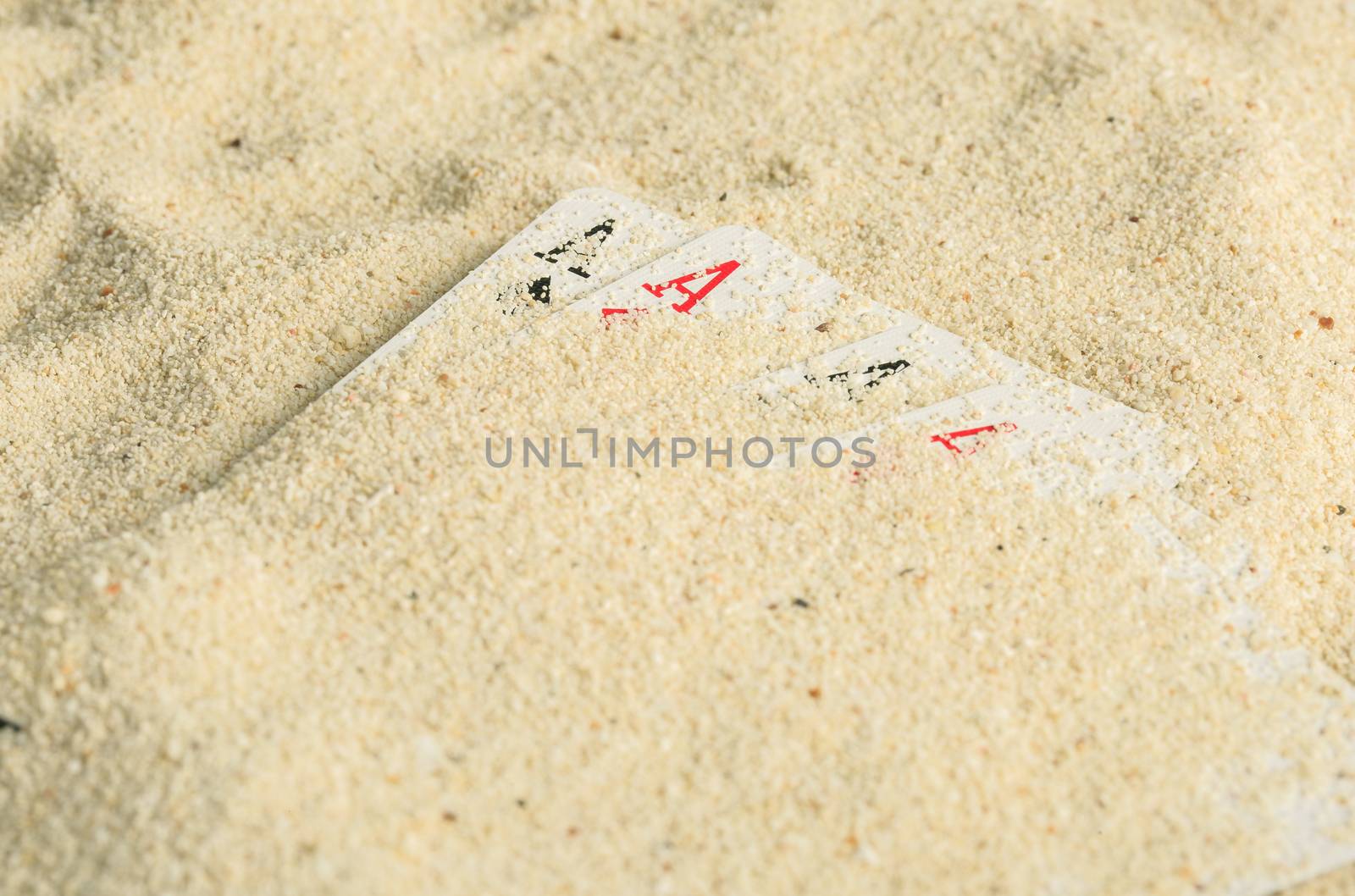 Poker playing cards buried  in a sand dune