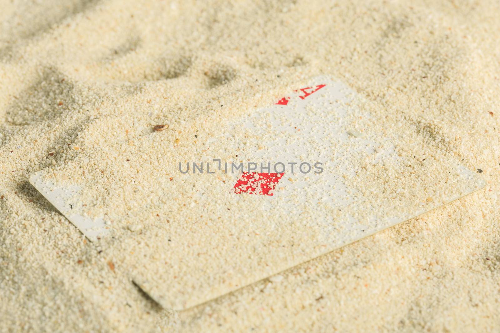 Poker playing cards buried  in a sand dune