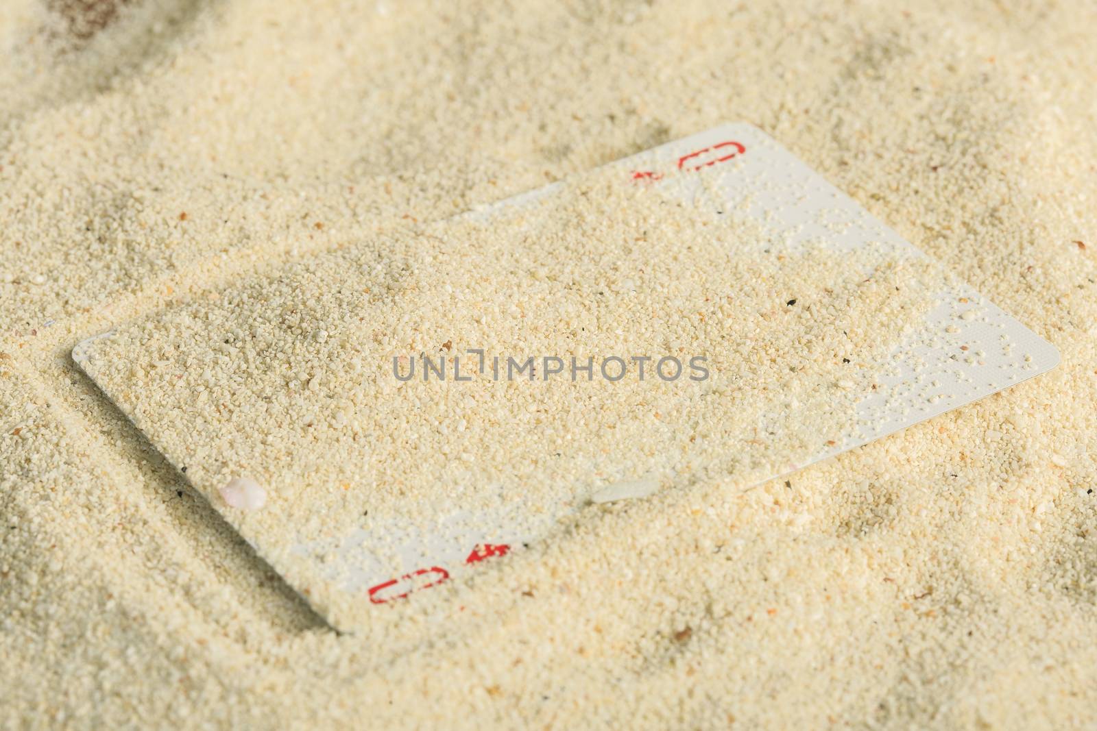 Poker playing cards buried  in a sand dune