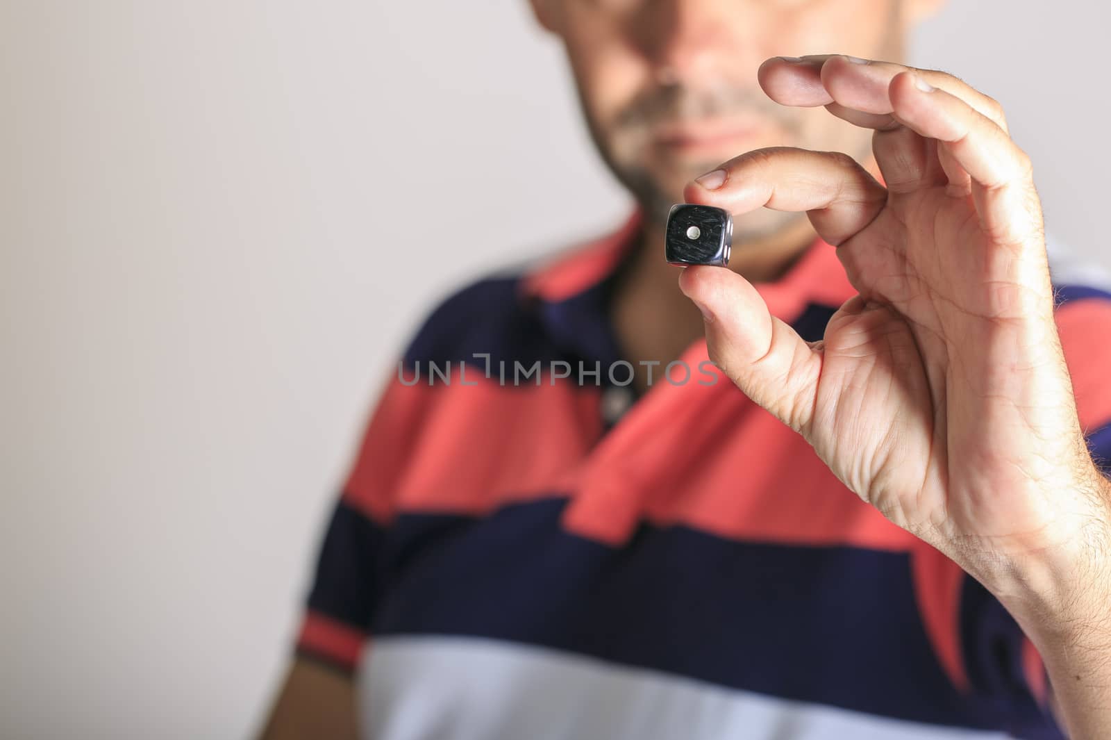 Man showing a dice  in his hand