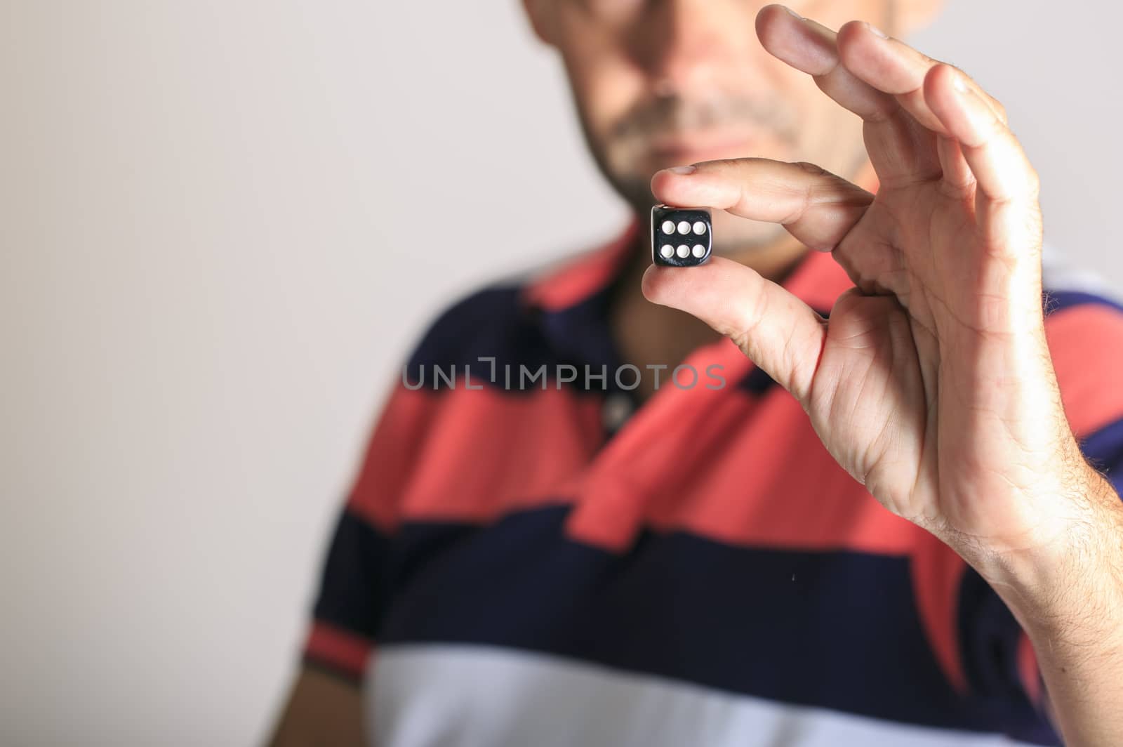 Man showing a dice  in his hand