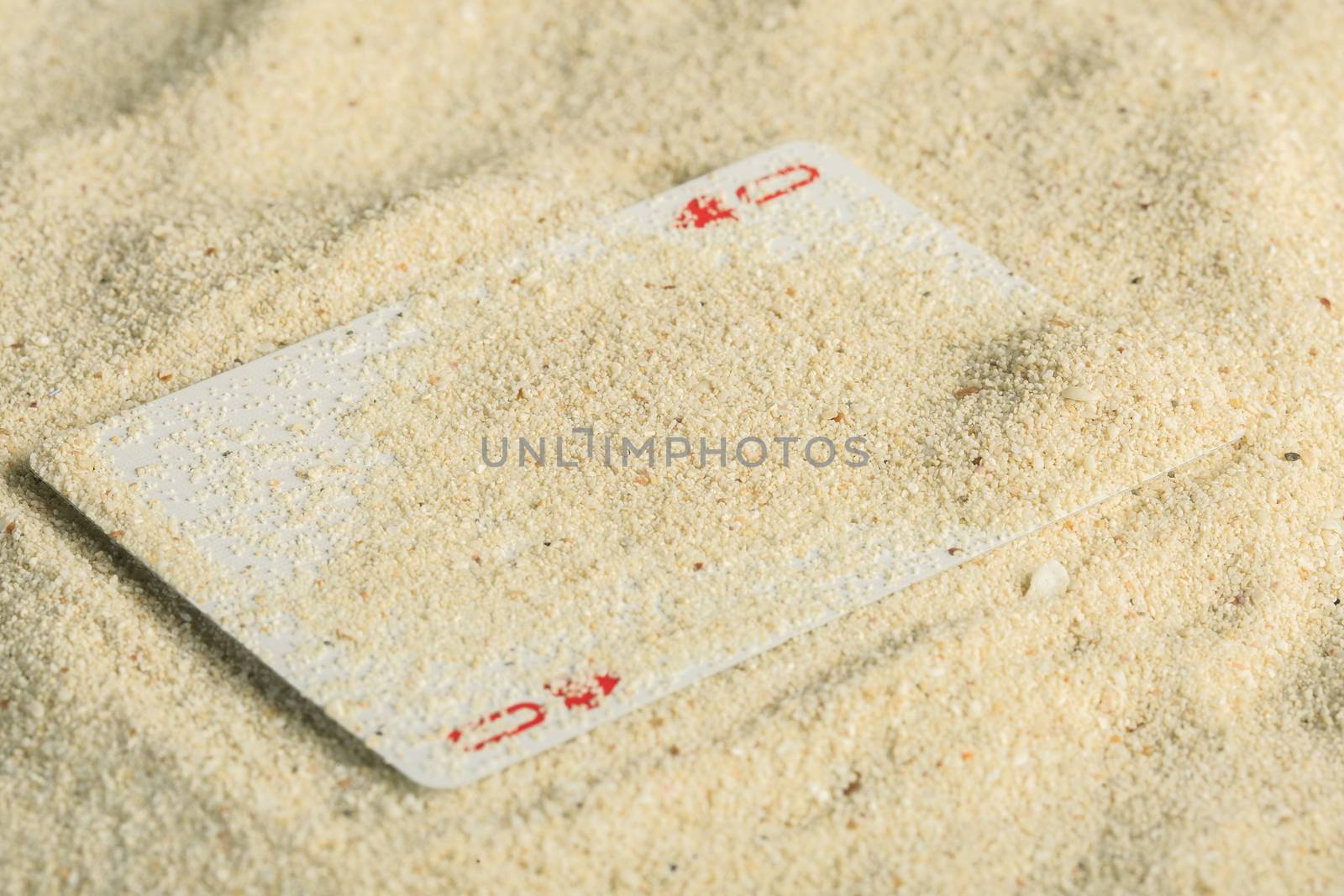 Poker playing cards buried  in a sand dune