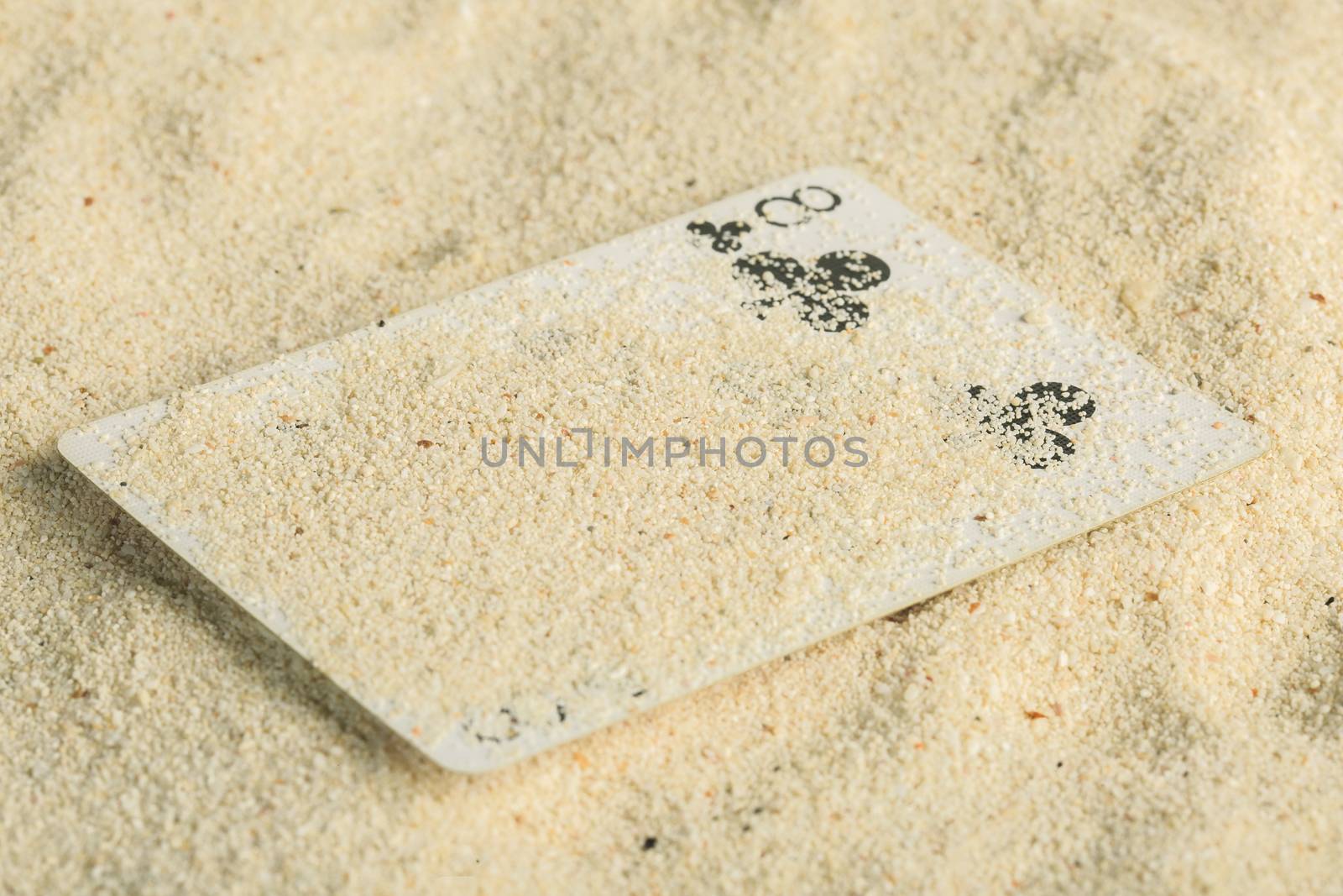 Poker playing cards buried  in a sand dune