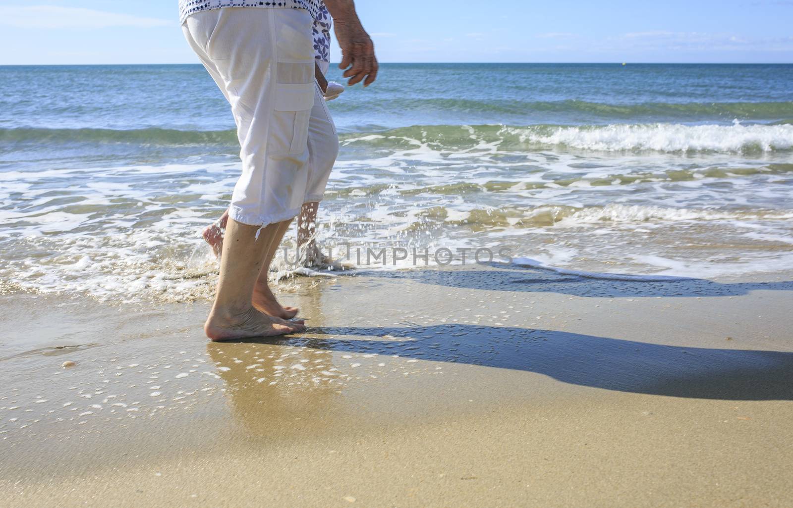Old people taking a walk on the beach