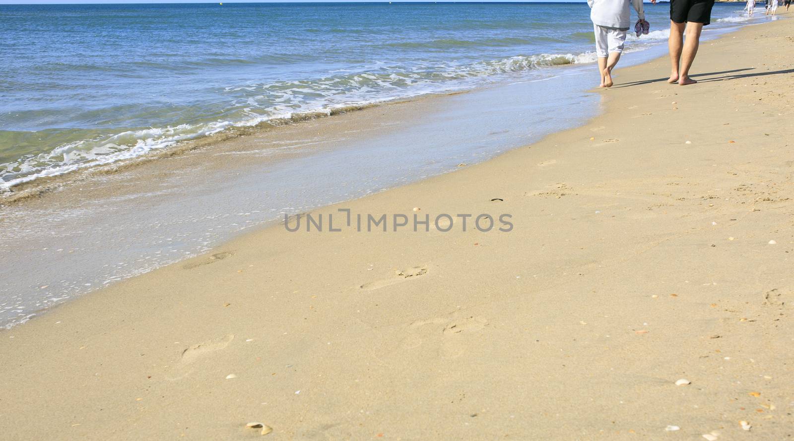 Old people taking a walk on the beach