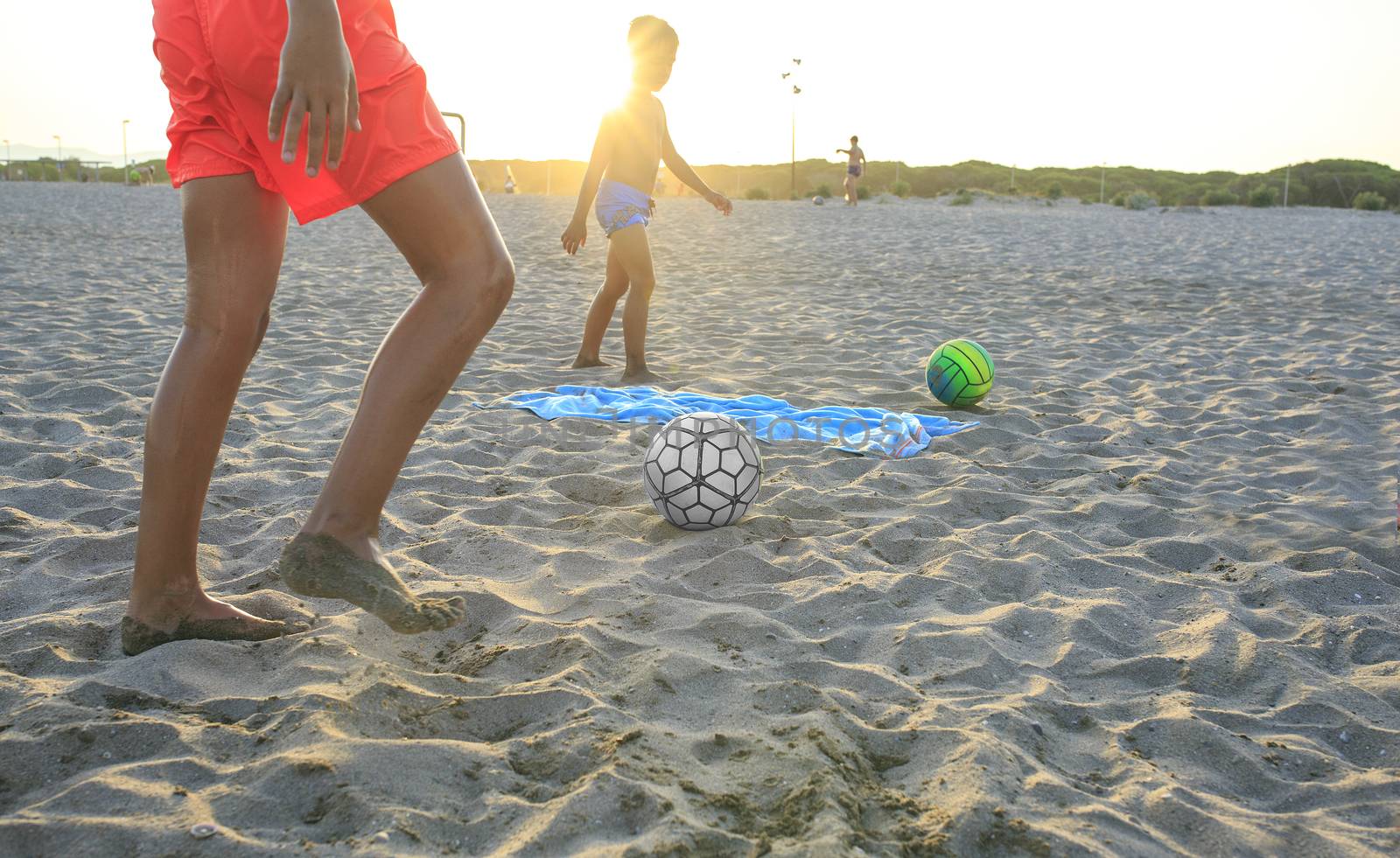 Boy playing football  on the beach