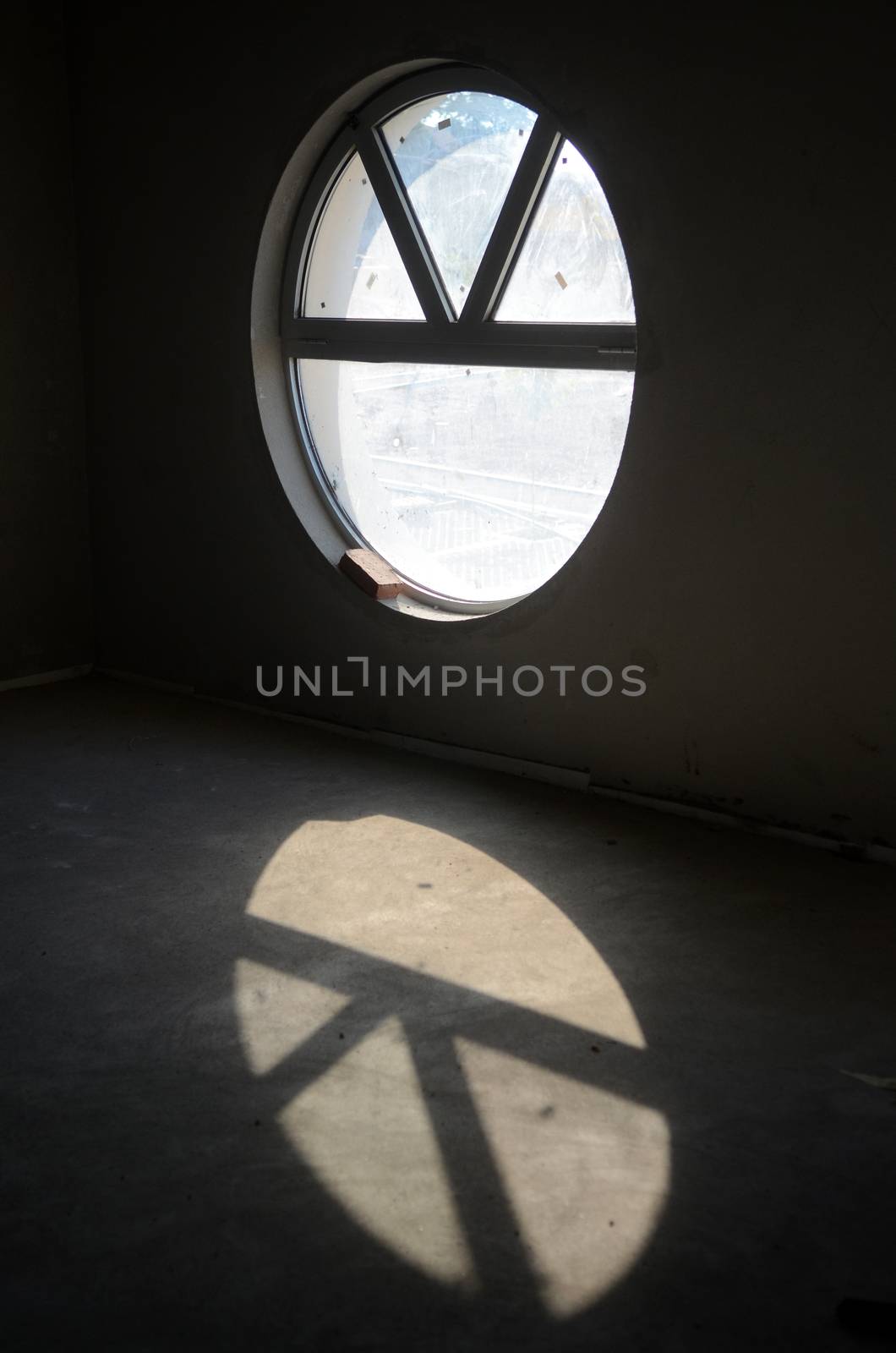 Concrete room with round window under construction