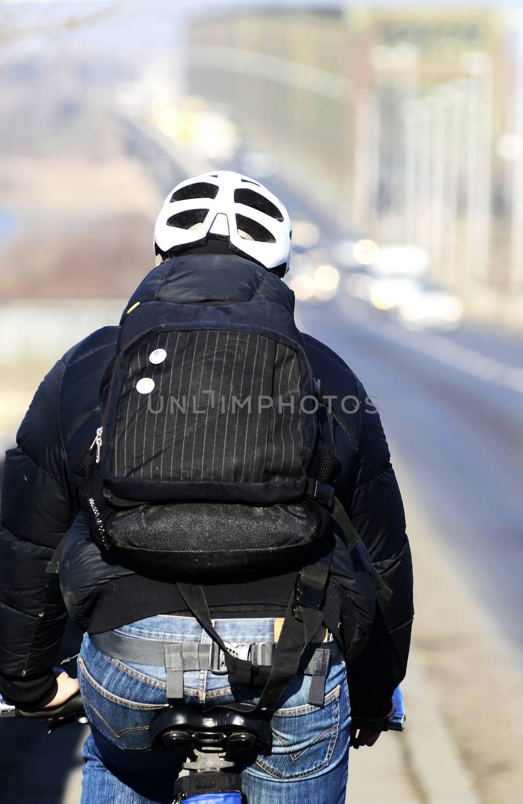 View from the back on cyclists with helmet and backpack