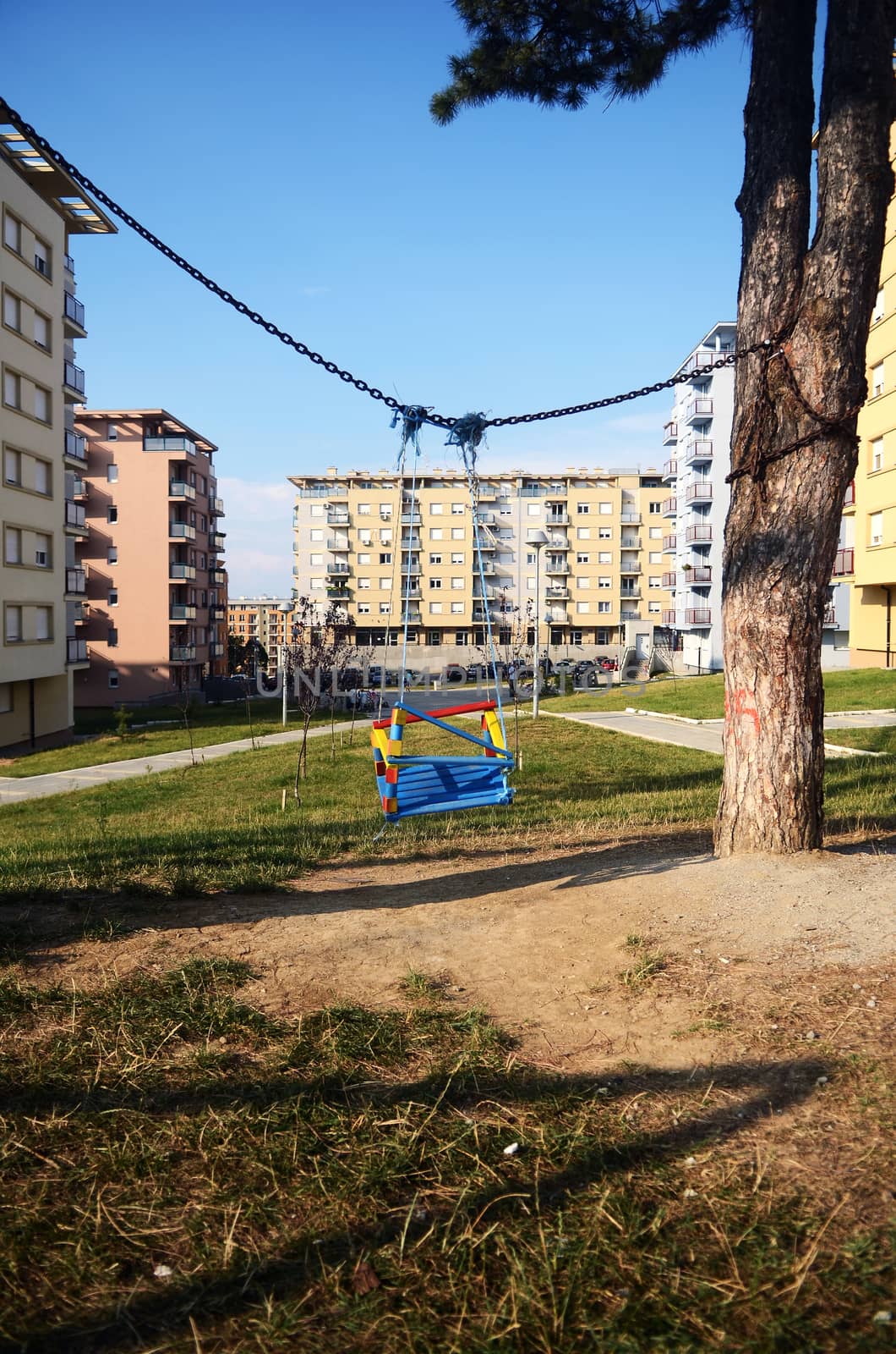 Empty swings in the playground in front of building