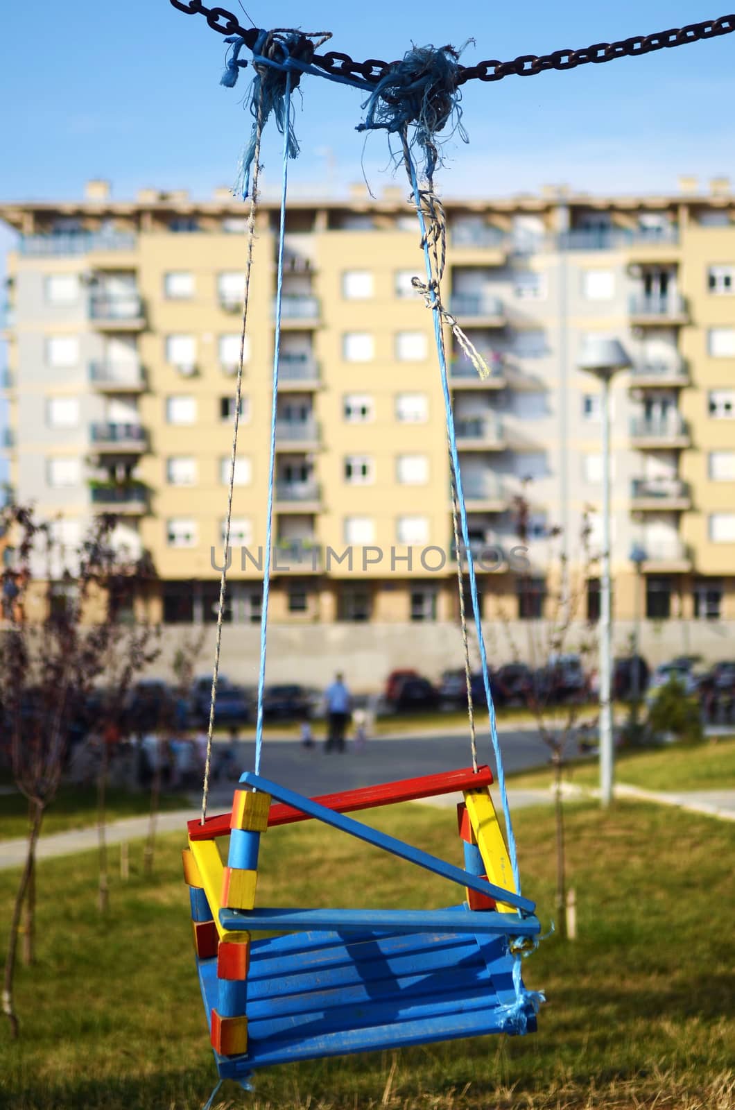Empty swings in the playground in front of building
