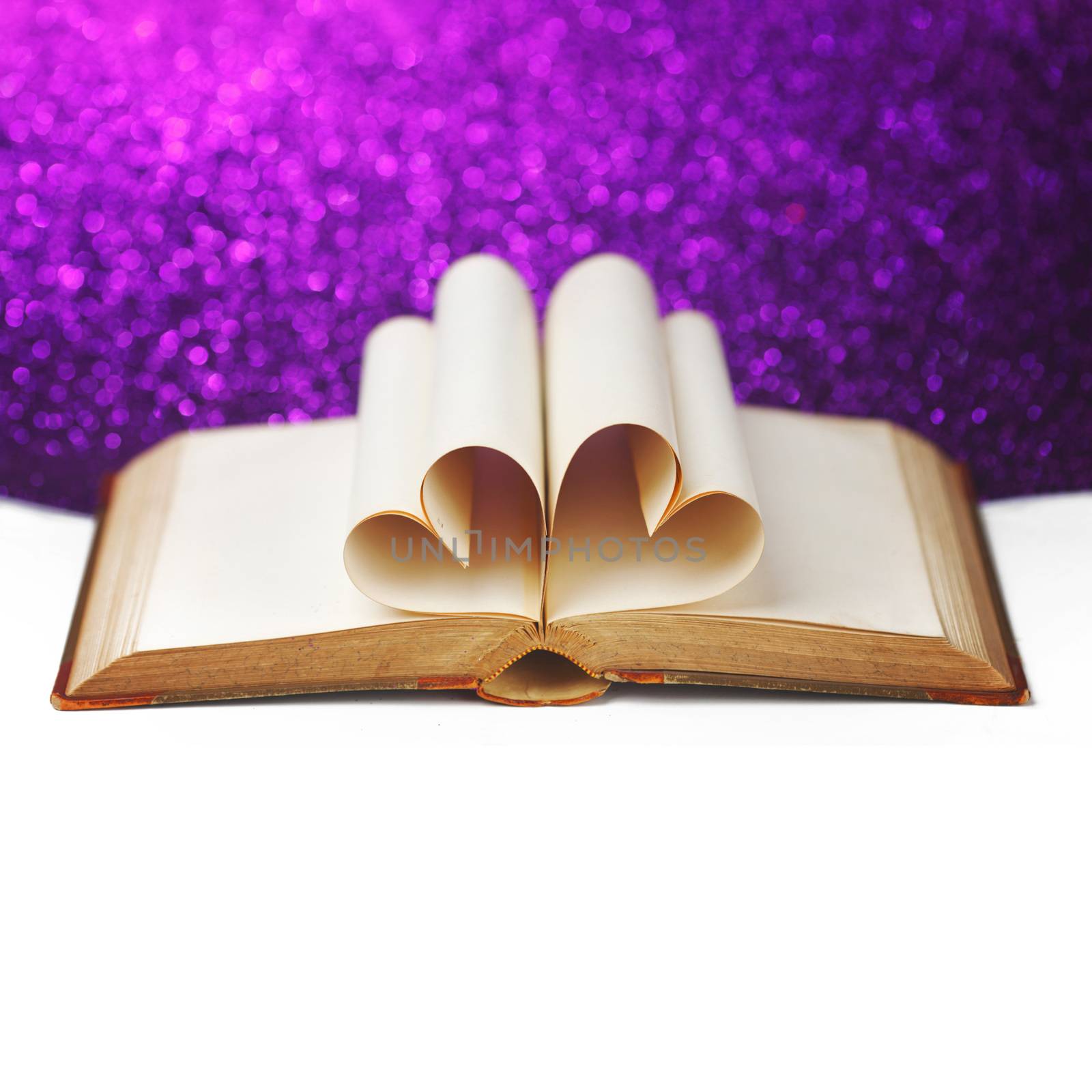 Heart shaped book pages on glitter background