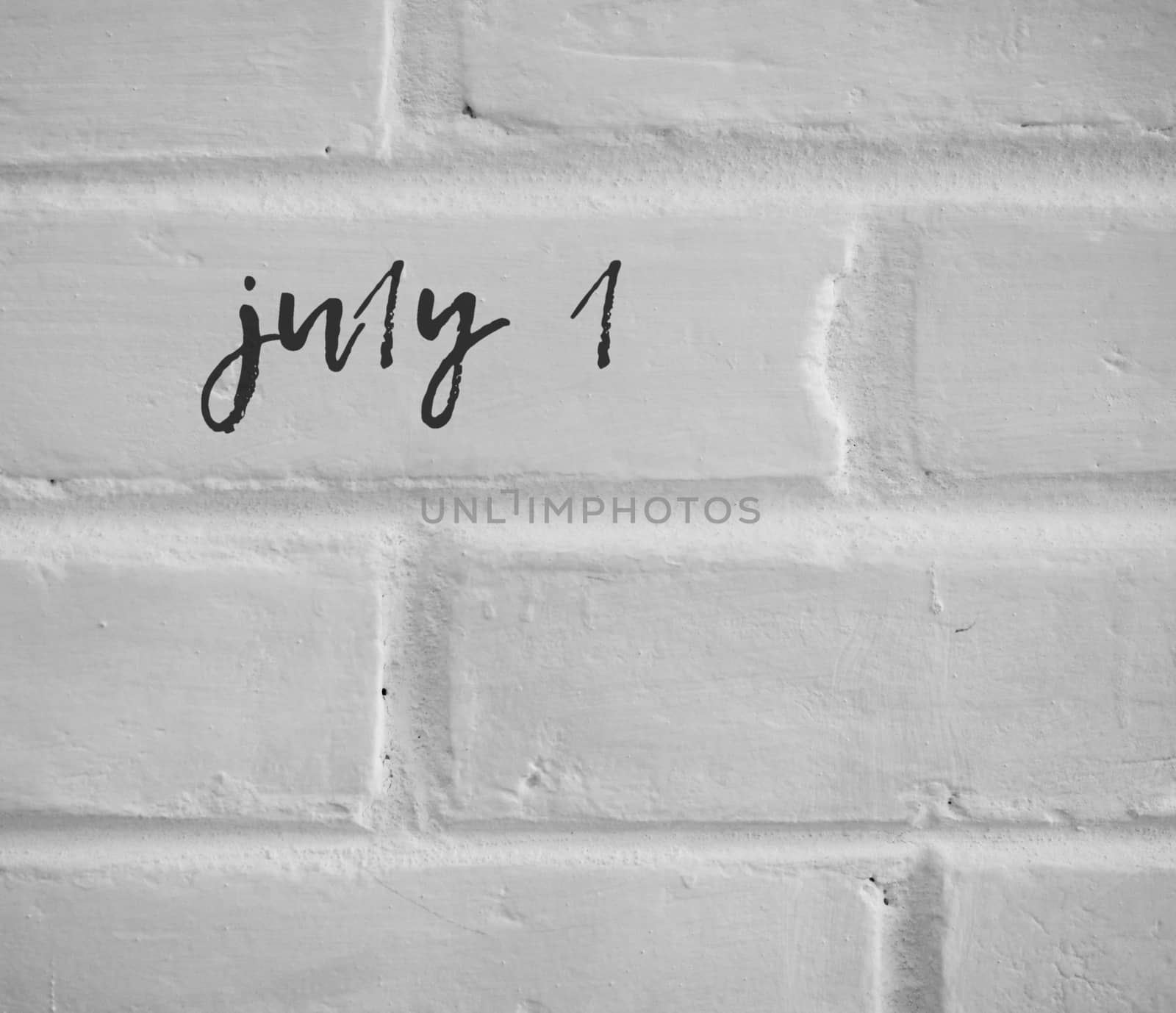 PHOTO OF july 1 WRITTEN ON WHITE PLAIN BRICK WALL