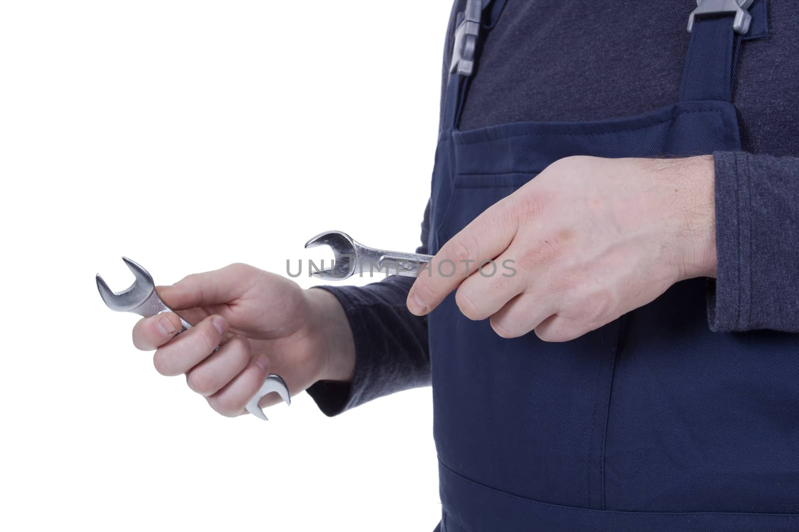 Hands of a wizard holding a wrench on a white background