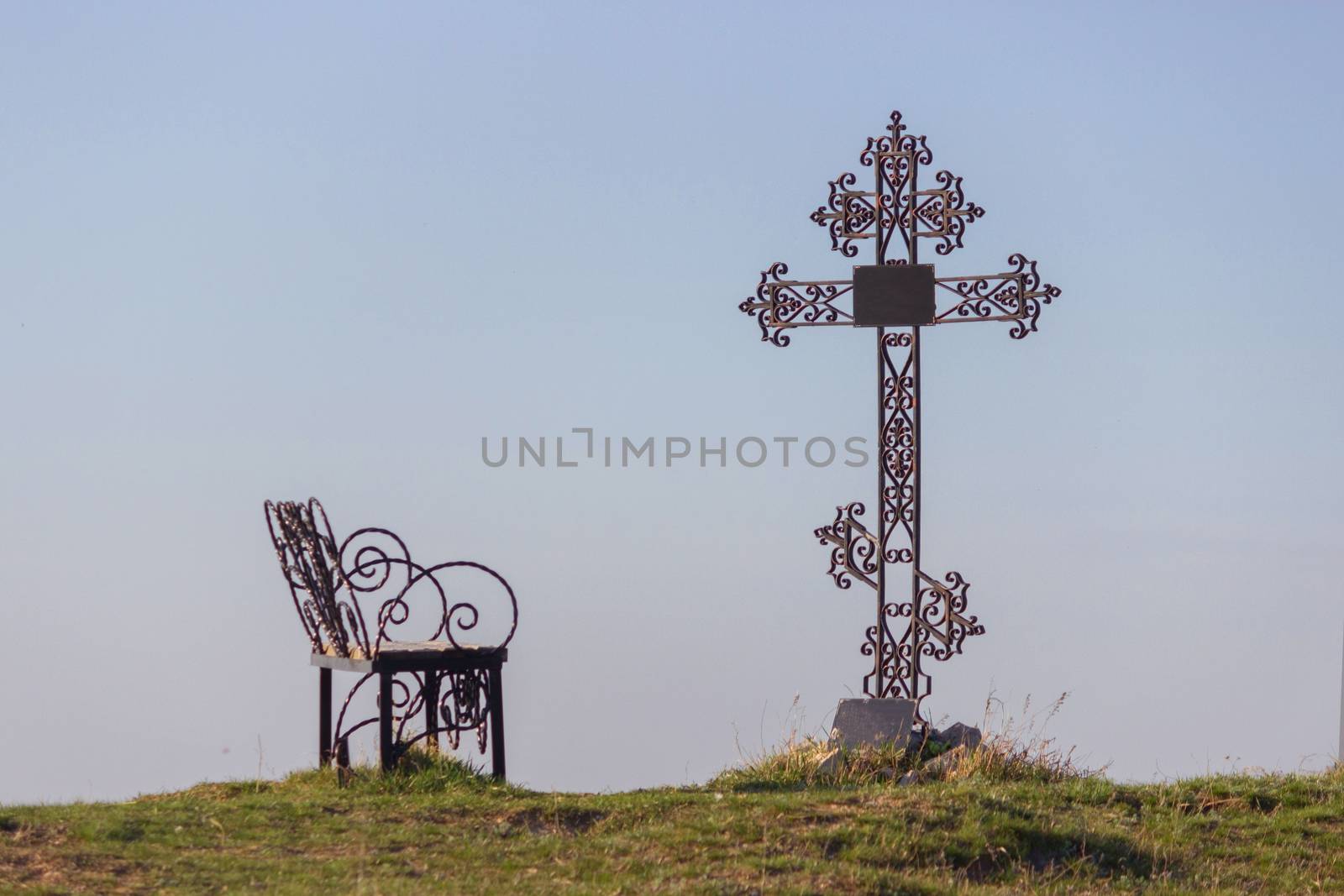 grave and a bench under ortodox cross
