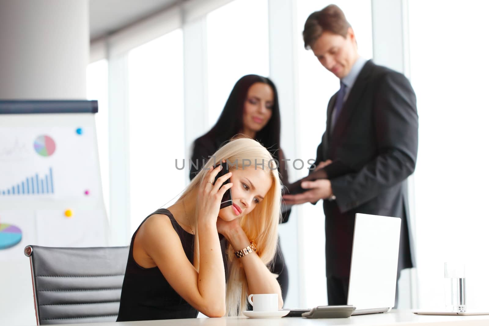 Young cute businesswoman talking on phone in office