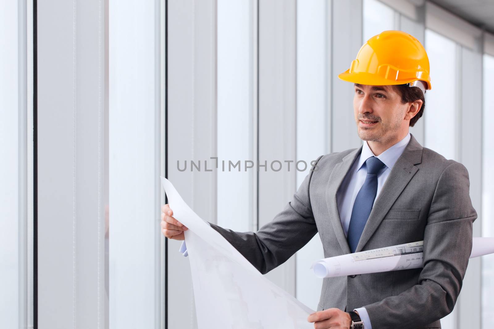 Architector in hardhat and business suit with construction plans