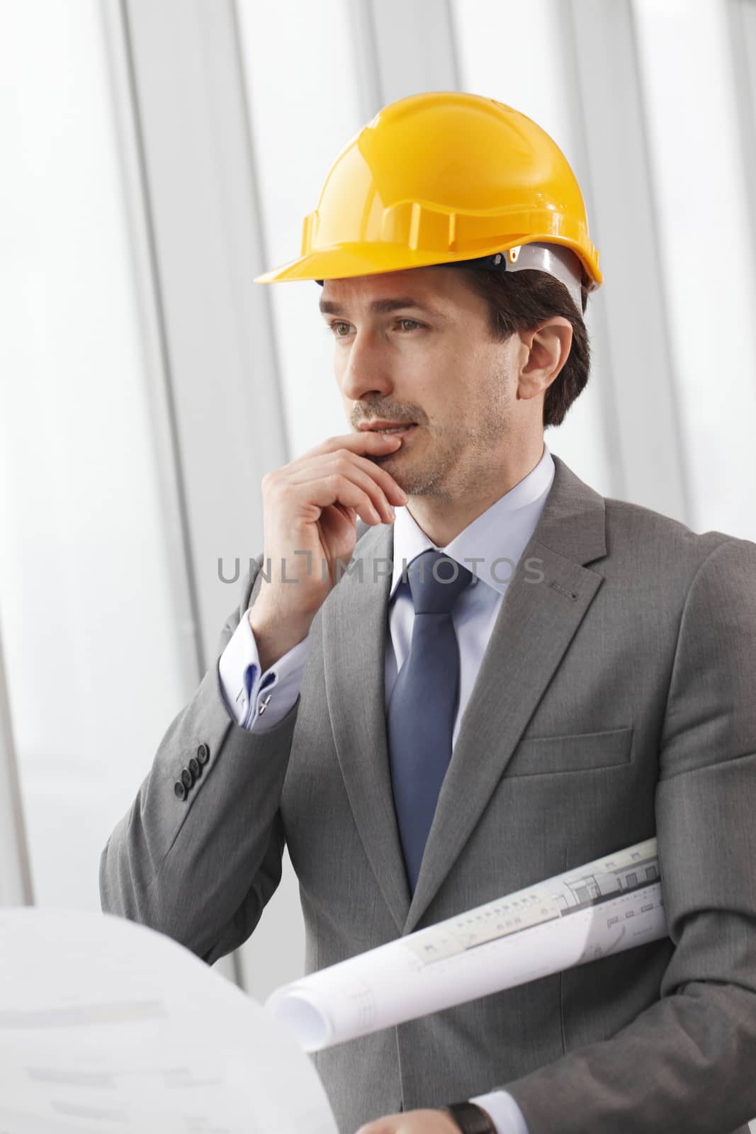 Architector in hardhat and business suit with construction plans