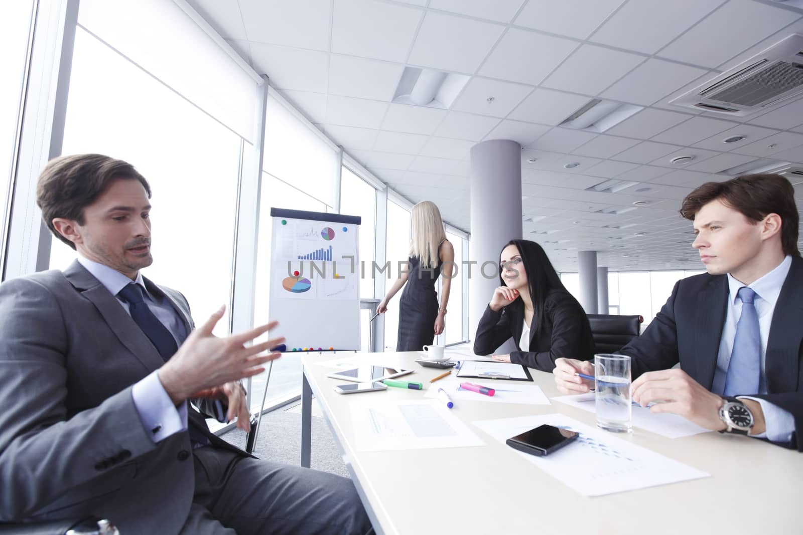 Workers at business meeting looking at presentation of financial reports in modern office
