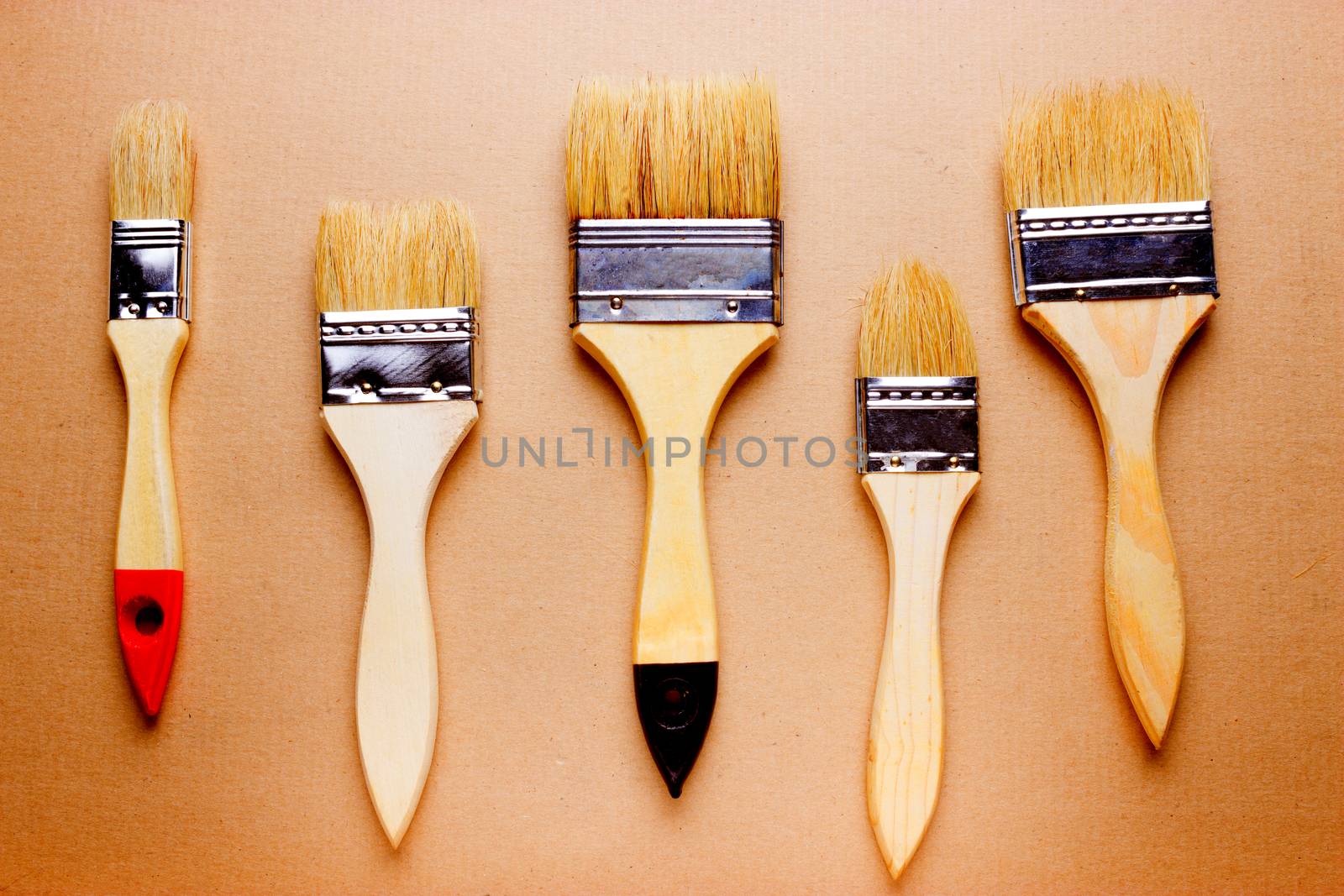 new different size paintbrushes on wood floor