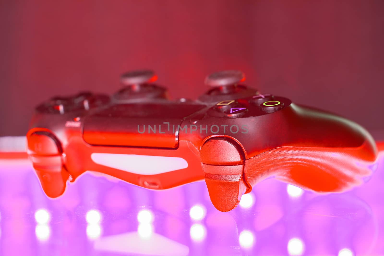 Game controller on illuminated table background. different colors