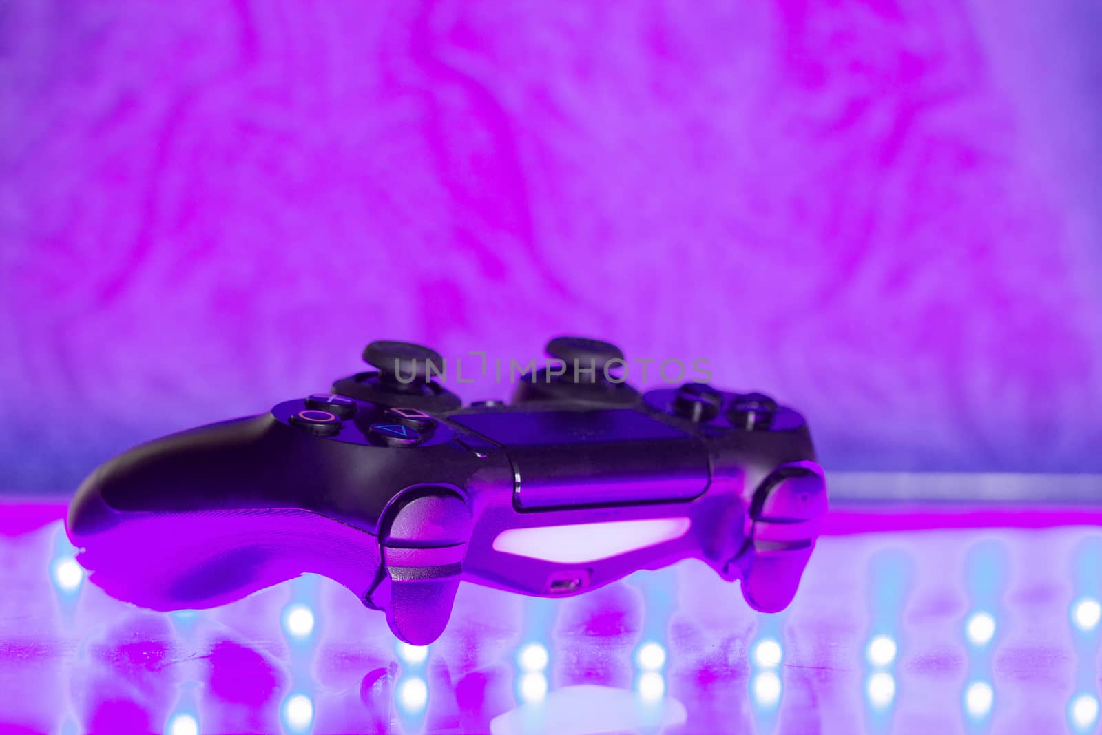 Game controller on illuminated table background. different colors