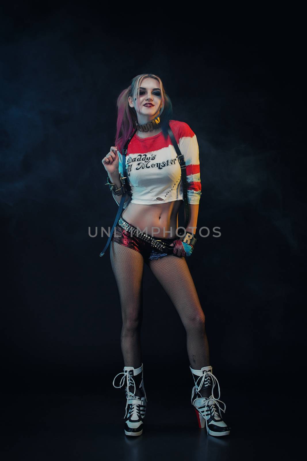 Cosplayer girl with in Harley Quinn costume. Halloween make up.