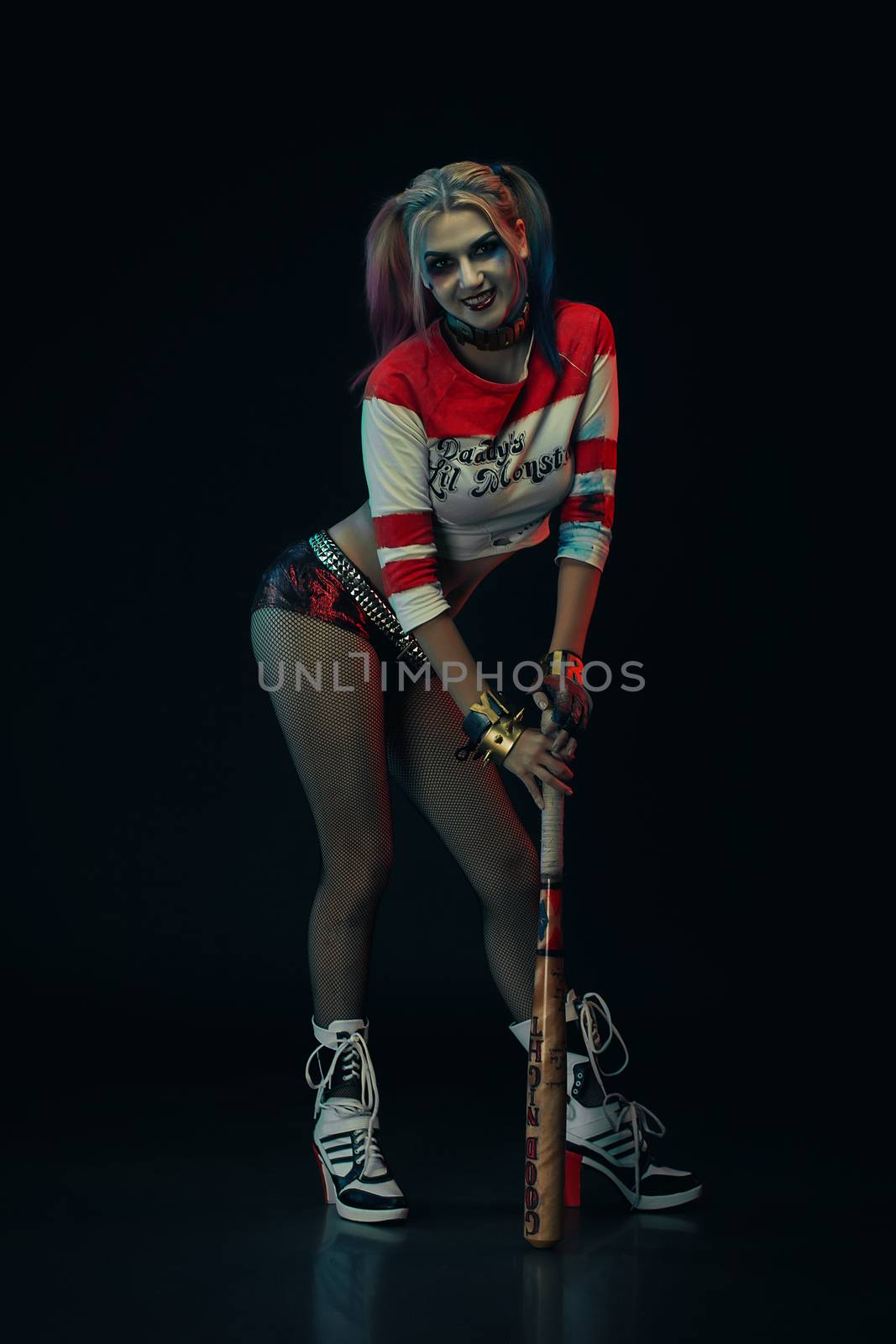 Cosplayer girl with in Harley Quinn costume. Halloween make up.