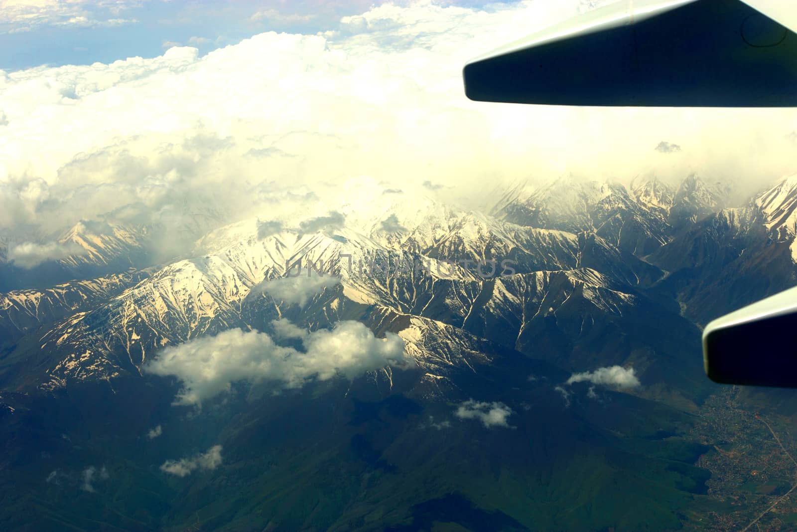 plain wing and mountains with snow below