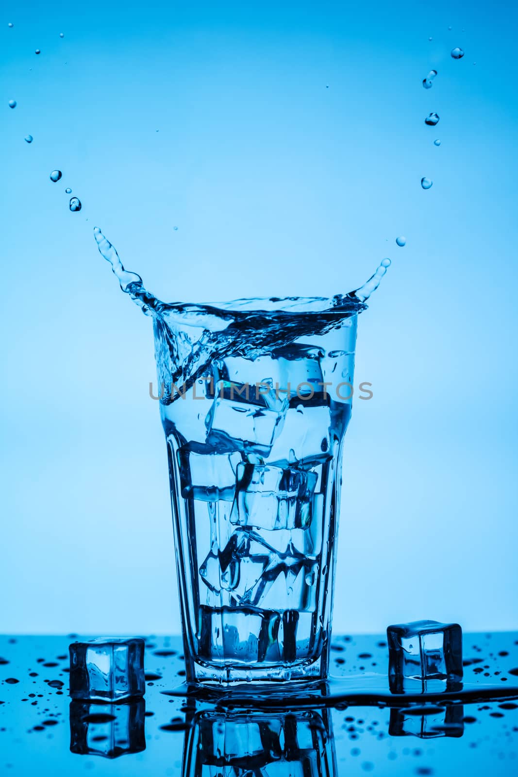 Splashing water from a glass with ice cubes