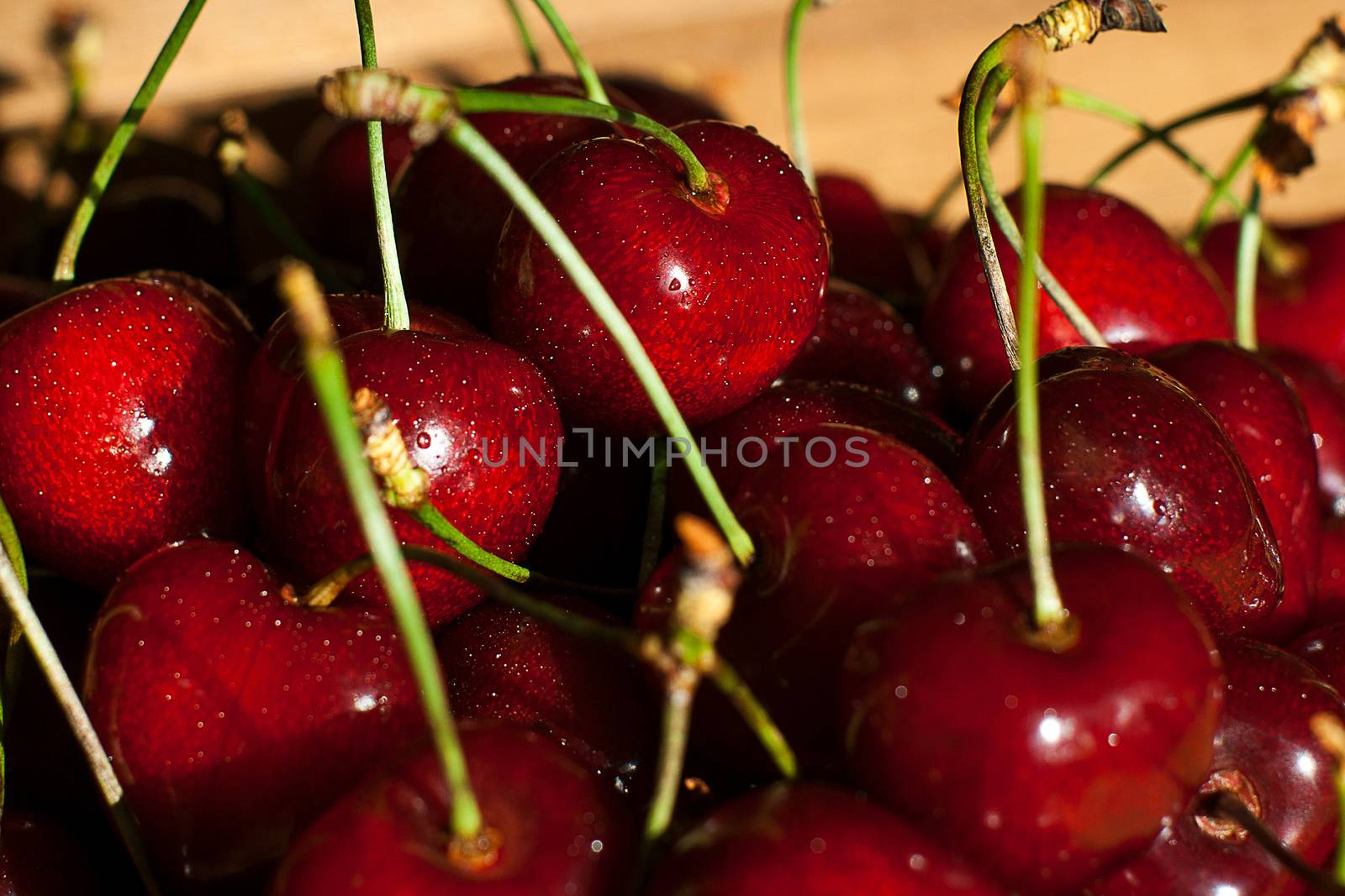 Fresh cherries in jar on the wooden background. Selective focus. Focus on the right cherries in front of jar.