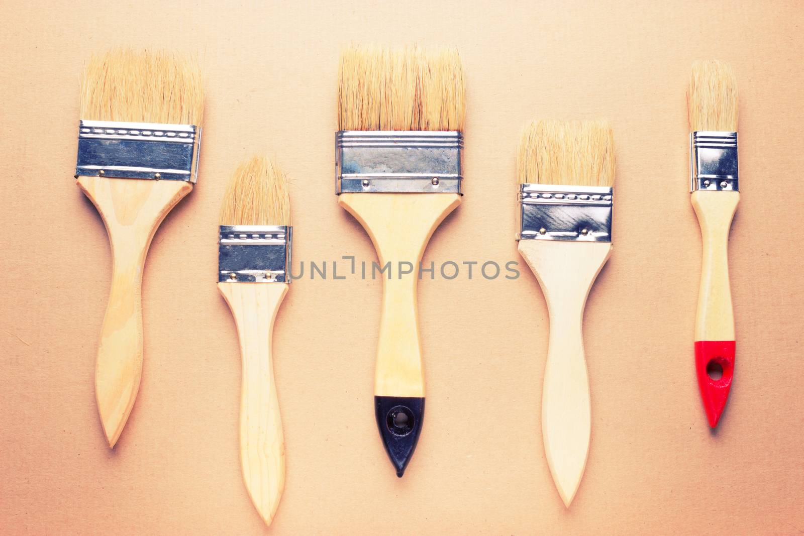 new different size paintbrushes on wood floor