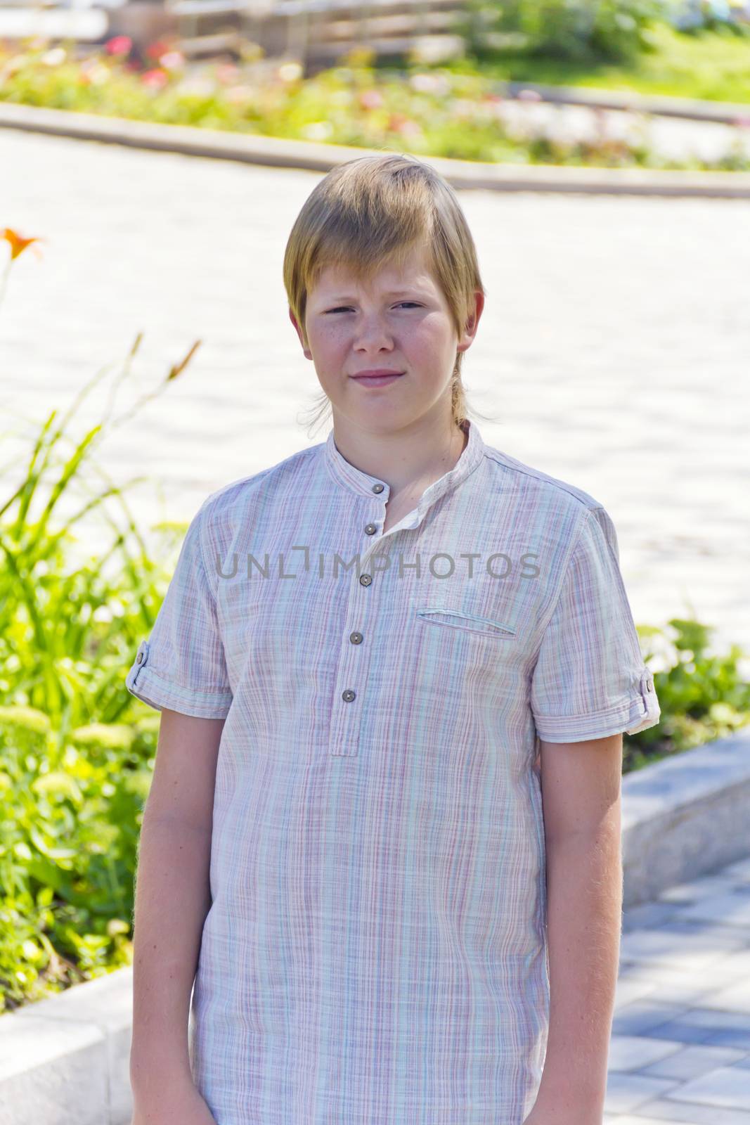 Portrait of serious boy in summer green park