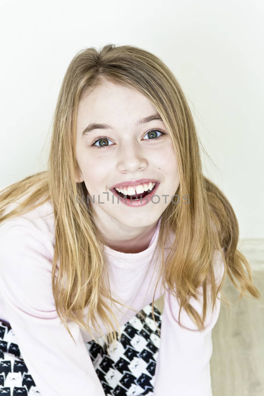 Laughing cute girl eleven years old are sitting on floor