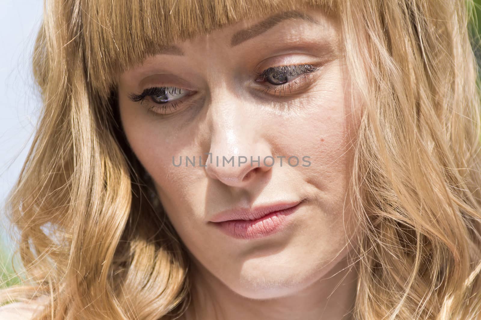 Horizontal portrait of young thinking woman with big blue eyes