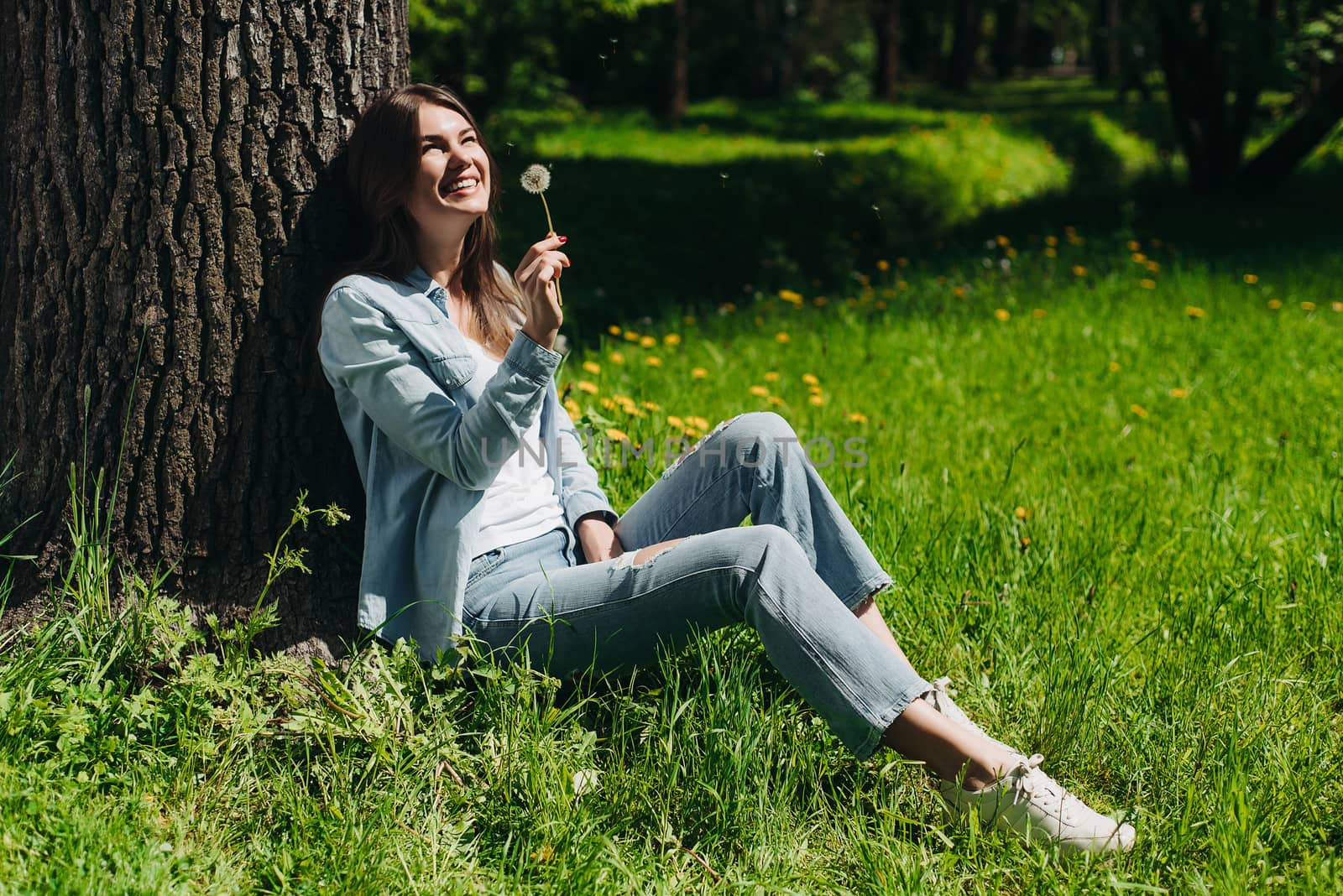 Woman with dandelion in park by ALotOfPeople