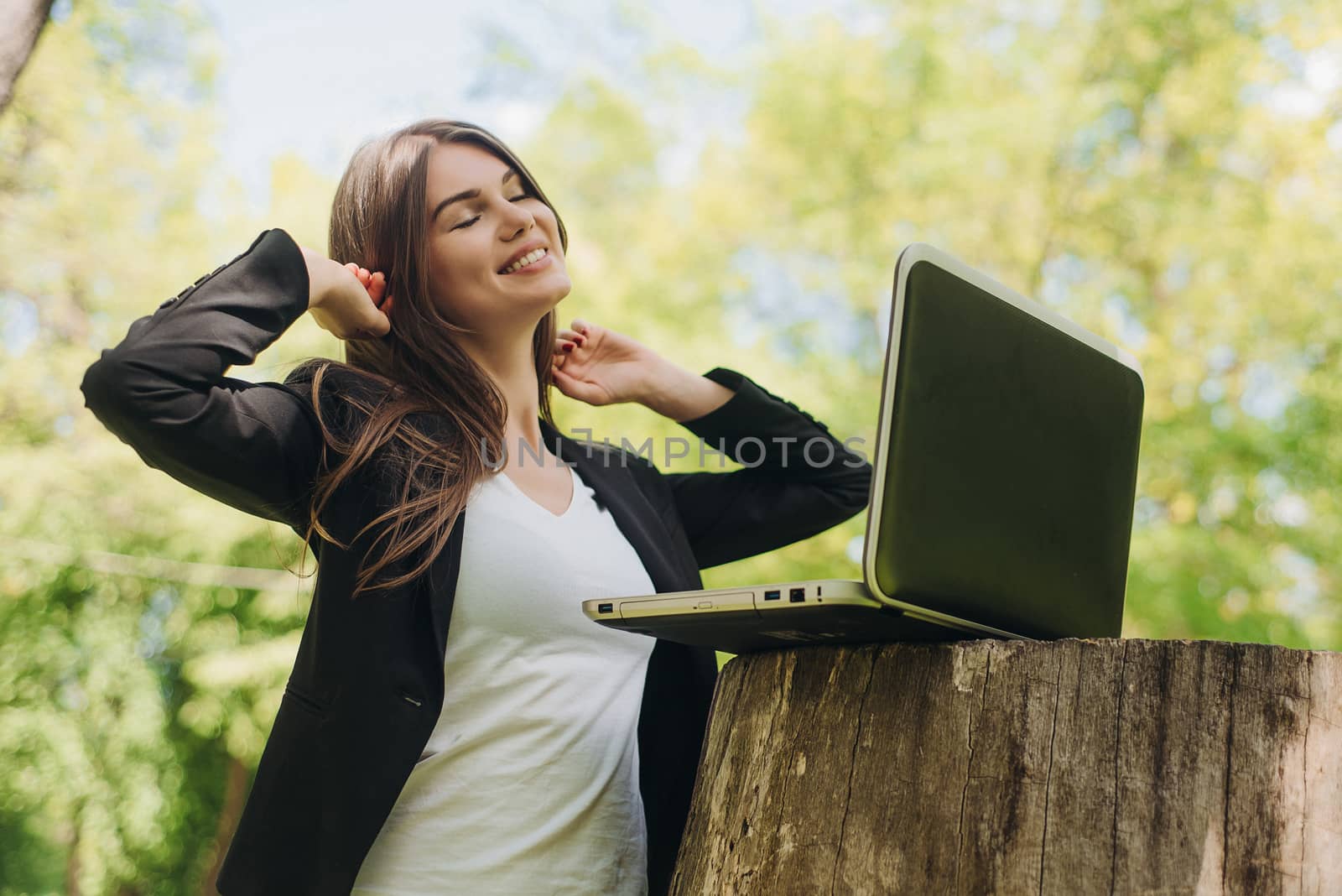 Beautiful business woman in suit using laptop computer in the park