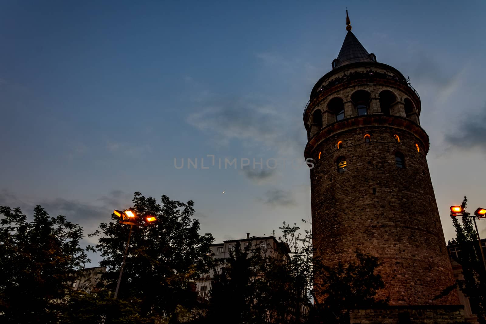 view to the Galata tower from the street while lights are switching on